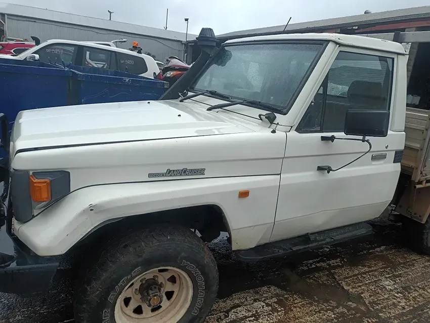 A White Truck is Parked in a Parking Lot Next to a Blue Truck — South West 4WD Wreckers In Brisbane, QLD