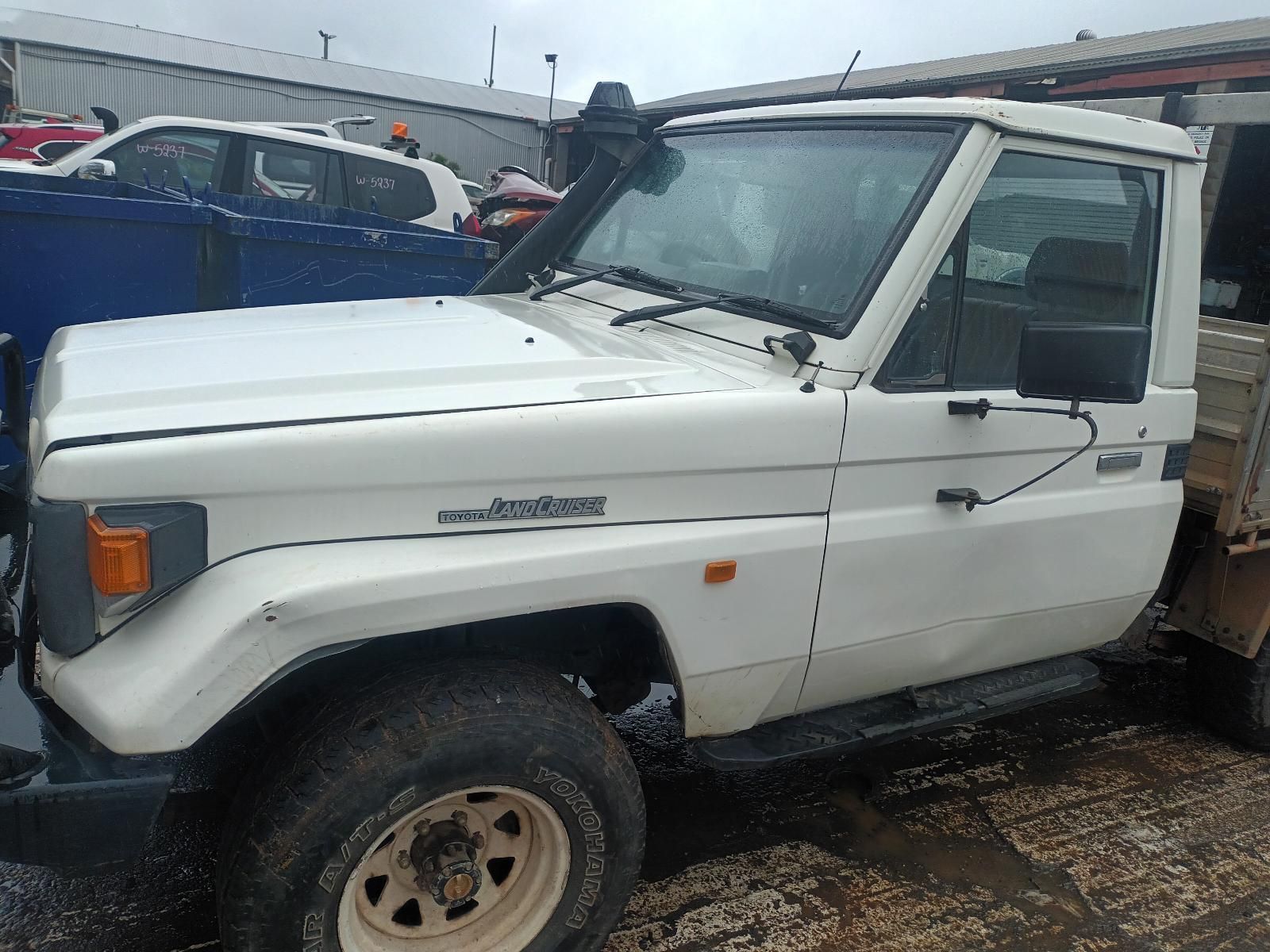 A White Truck is Parked in a Parking Lot Next to a Blue Truck — South West 4WD Wreckers in Harristown, QLD