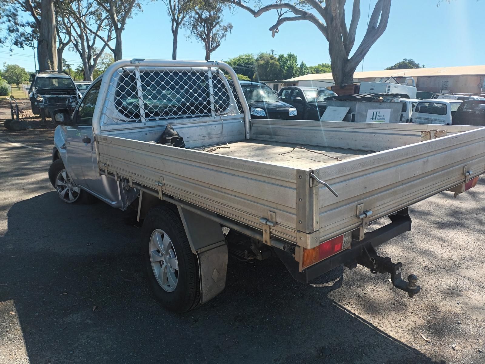 A Silver Truck with a Flat Bed is Parked in a Parking Lot — South West 4WD Wreckers in Harristown, QLD