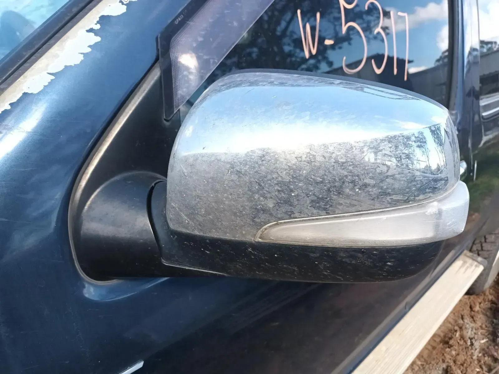 Side Mirror of a Dark Vehicle With a Chrome-like Finish and a Clear Turn Signal — South West 4WD Wreckers In Brisbane, QLD