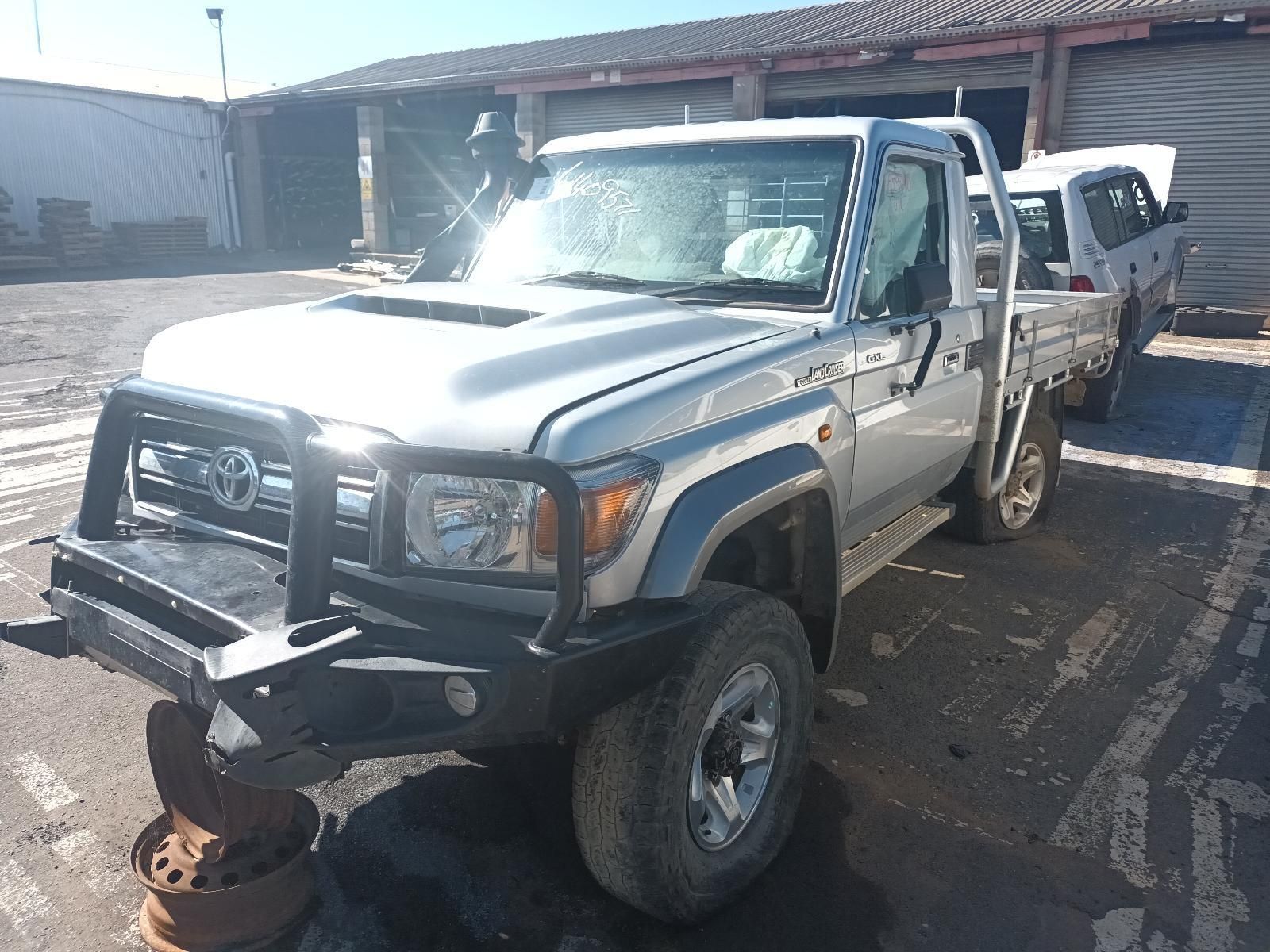 A Silver Truck is Parked in a Parking Lot Next to a Building — South West 4WD Wreckers in Harristown, QLD 