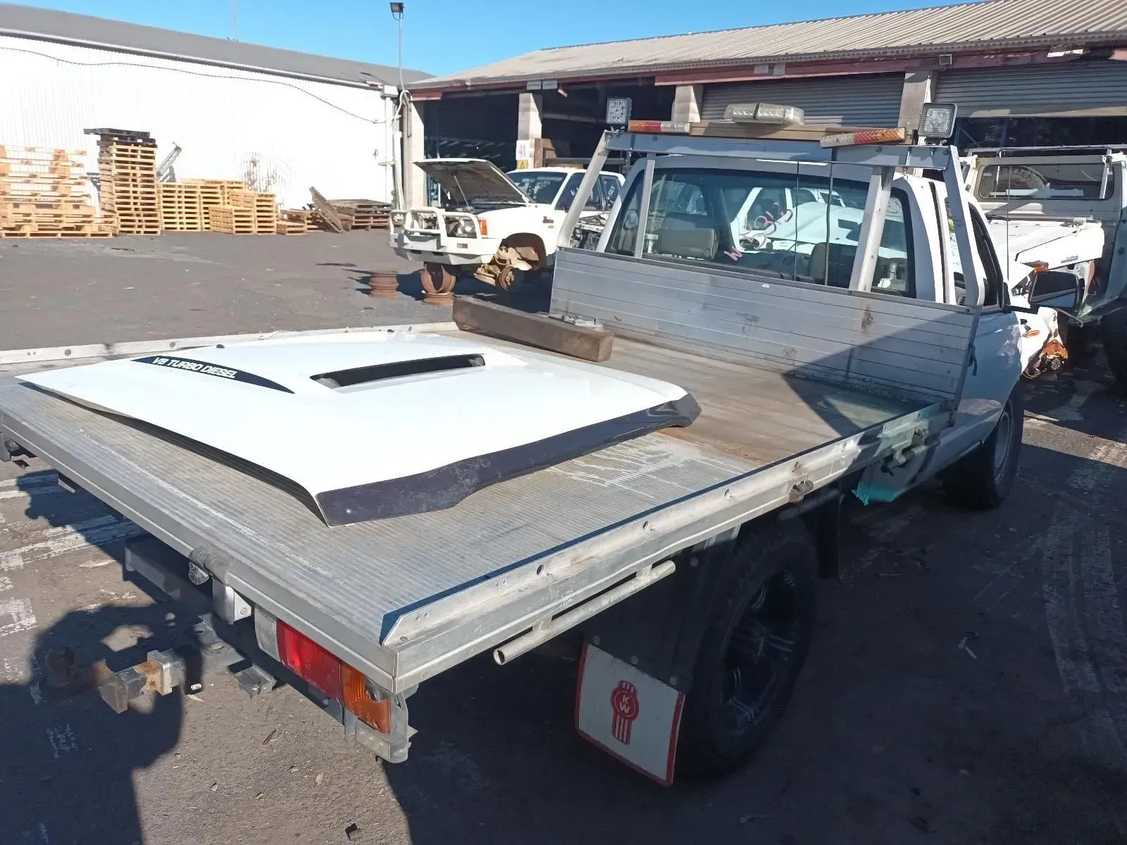 White Pickup Truck With Flatbed in a Yard, Hood Removed — South West 4WD Wreckers In Brisbane, QLD