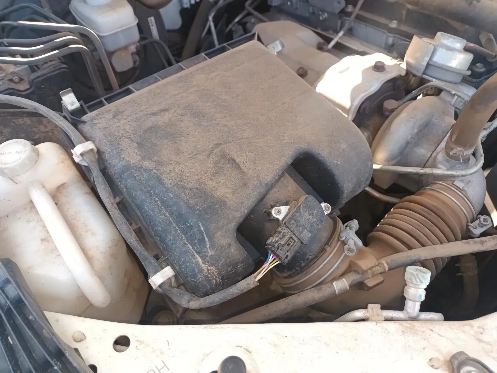 Car Engine Compartment, Dusty Black Air Filter Housing, Coolant Reservoir Visible — South West 4WD Wreckers In Brisbane, QLD