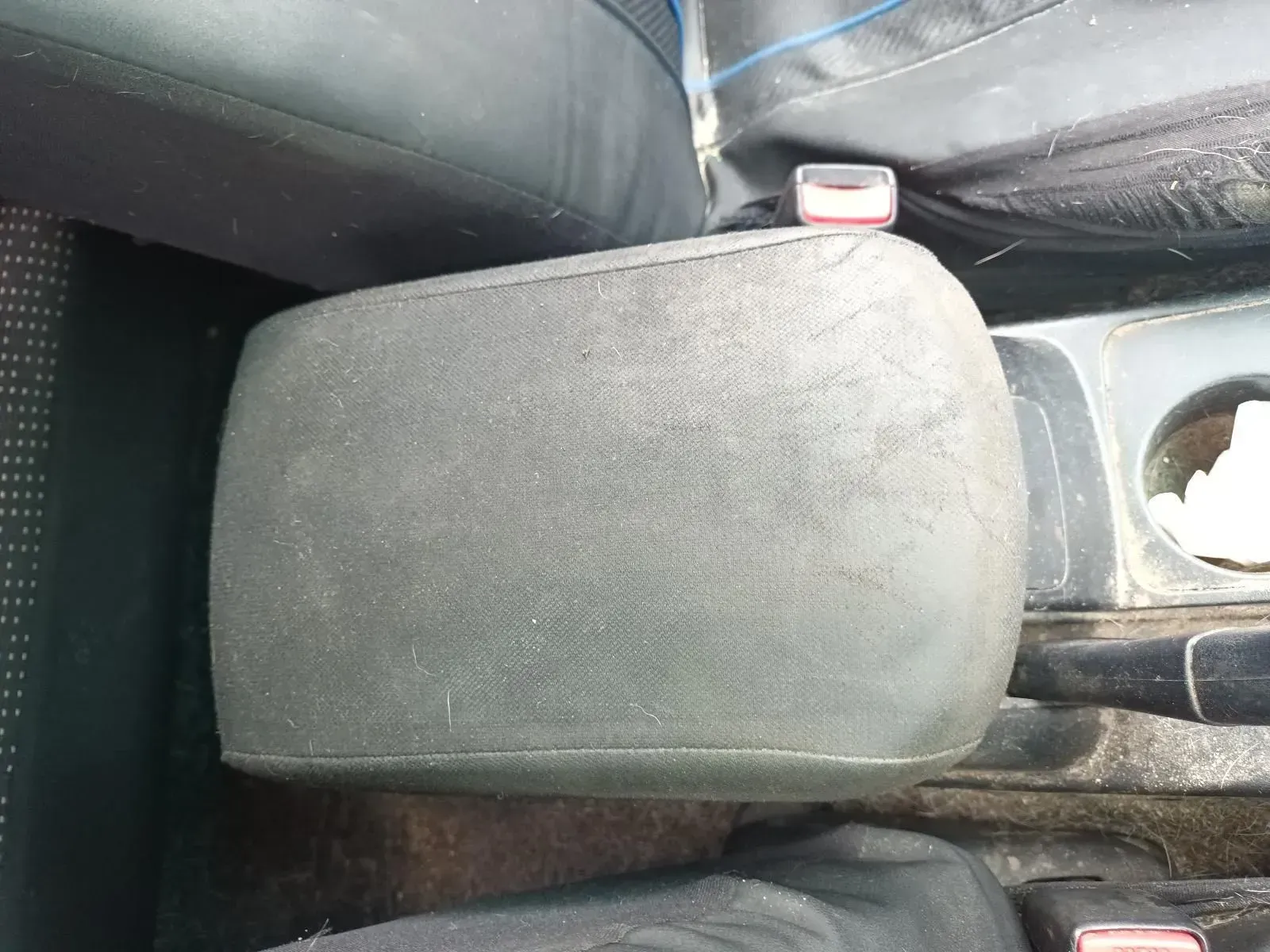 Black Car Armrest, Dusty, Between Seats With Seatbelt Buckle Visible — South West 4WD Wreckers In Brisbane, QLD