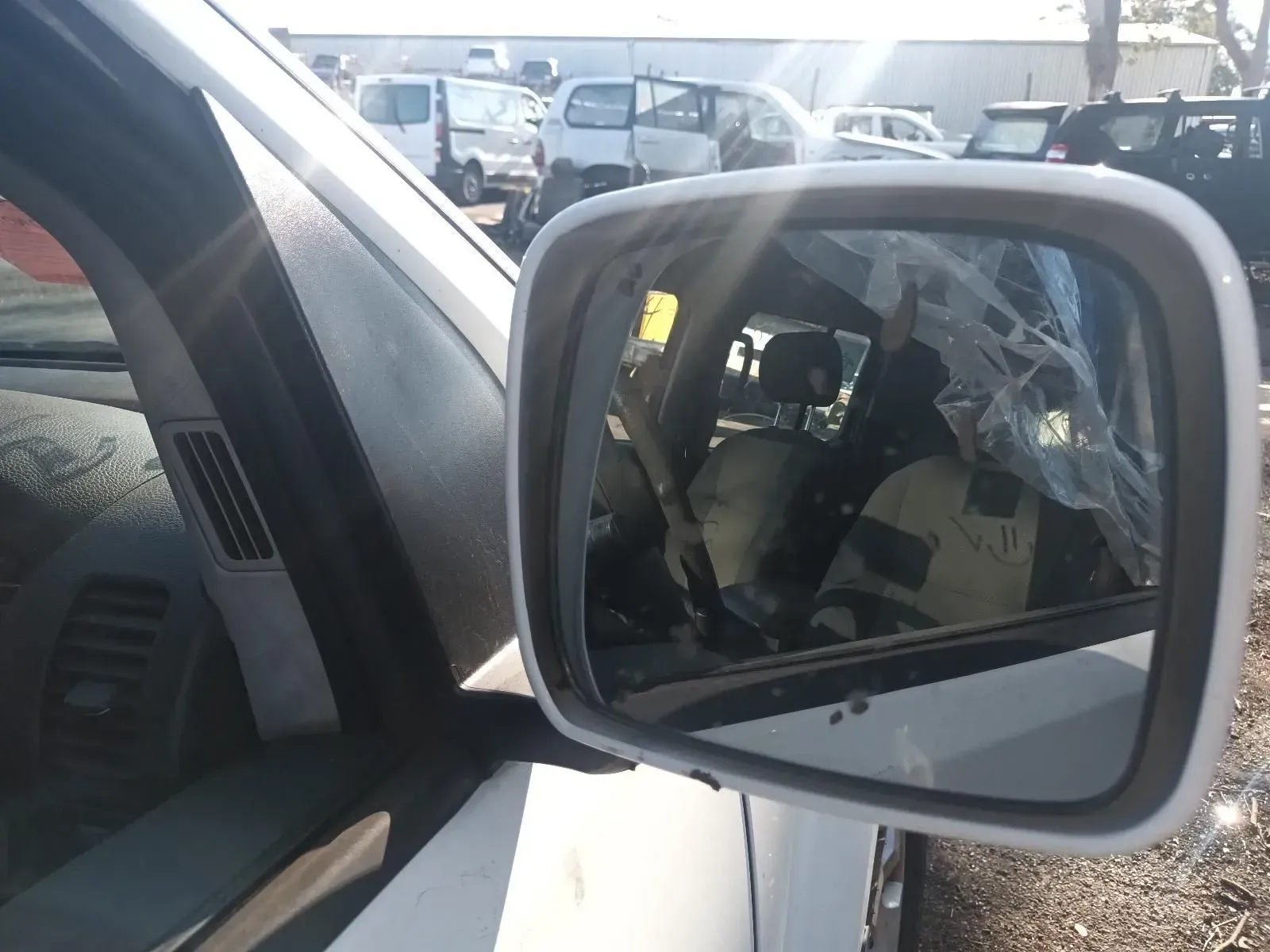 Side View Mirror Reflecting a Driver Wearing a Vest Inside a White Vehicle — South West 4WD Wreckers In Brisbane, QLD