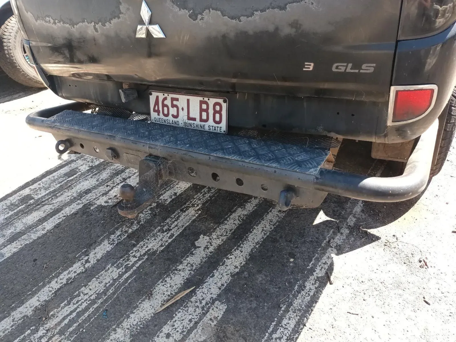 Rear View of a Black Mitsubishi Triton With a Modified Bumper and Tow Hitch — South West 4WD Wreckers In Brisbane, QLD