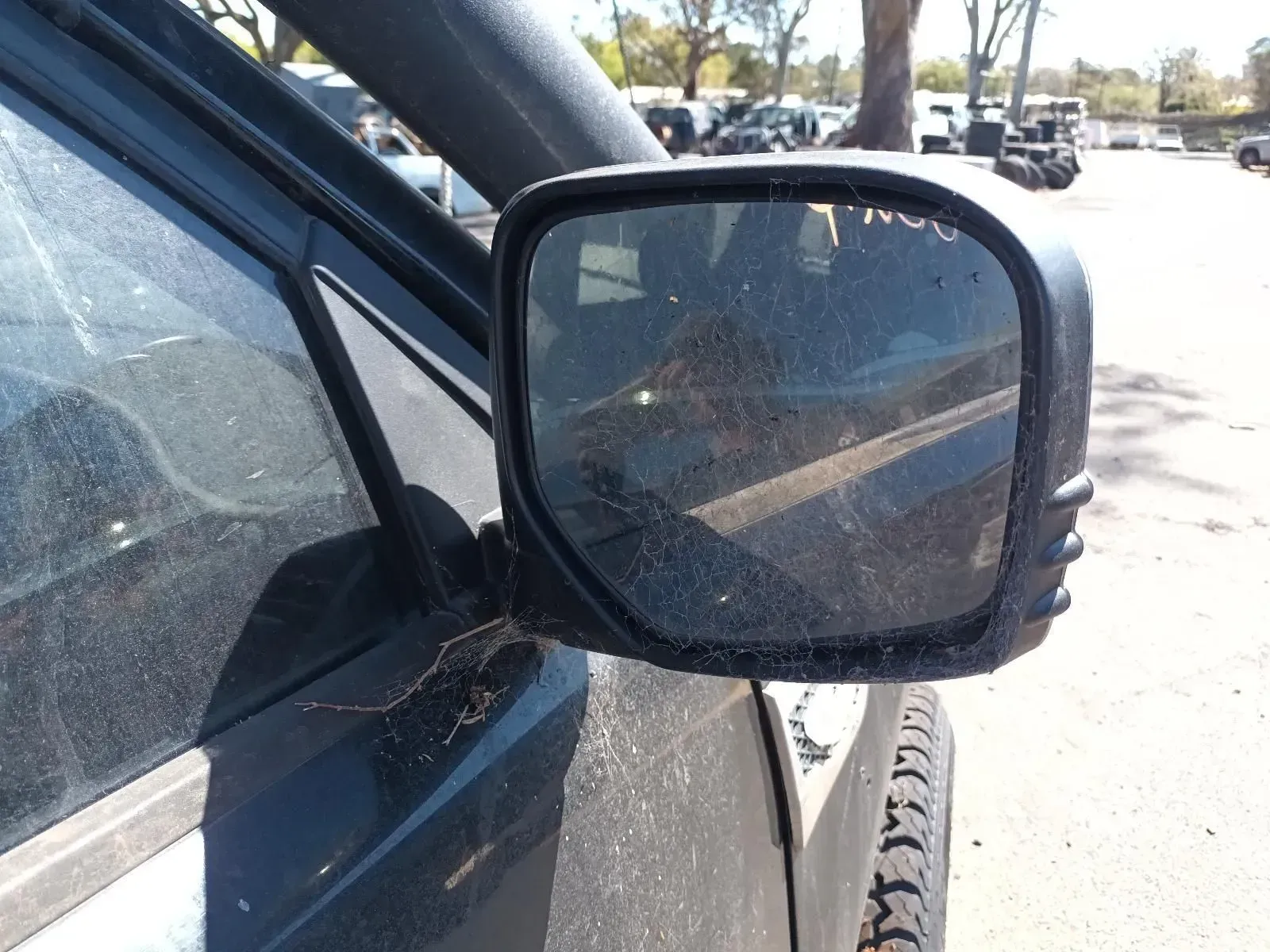 A Dirty Side Mirror on a Dark-colored Vehicle — South West 4WD Wreckers In Brisbane, QLD