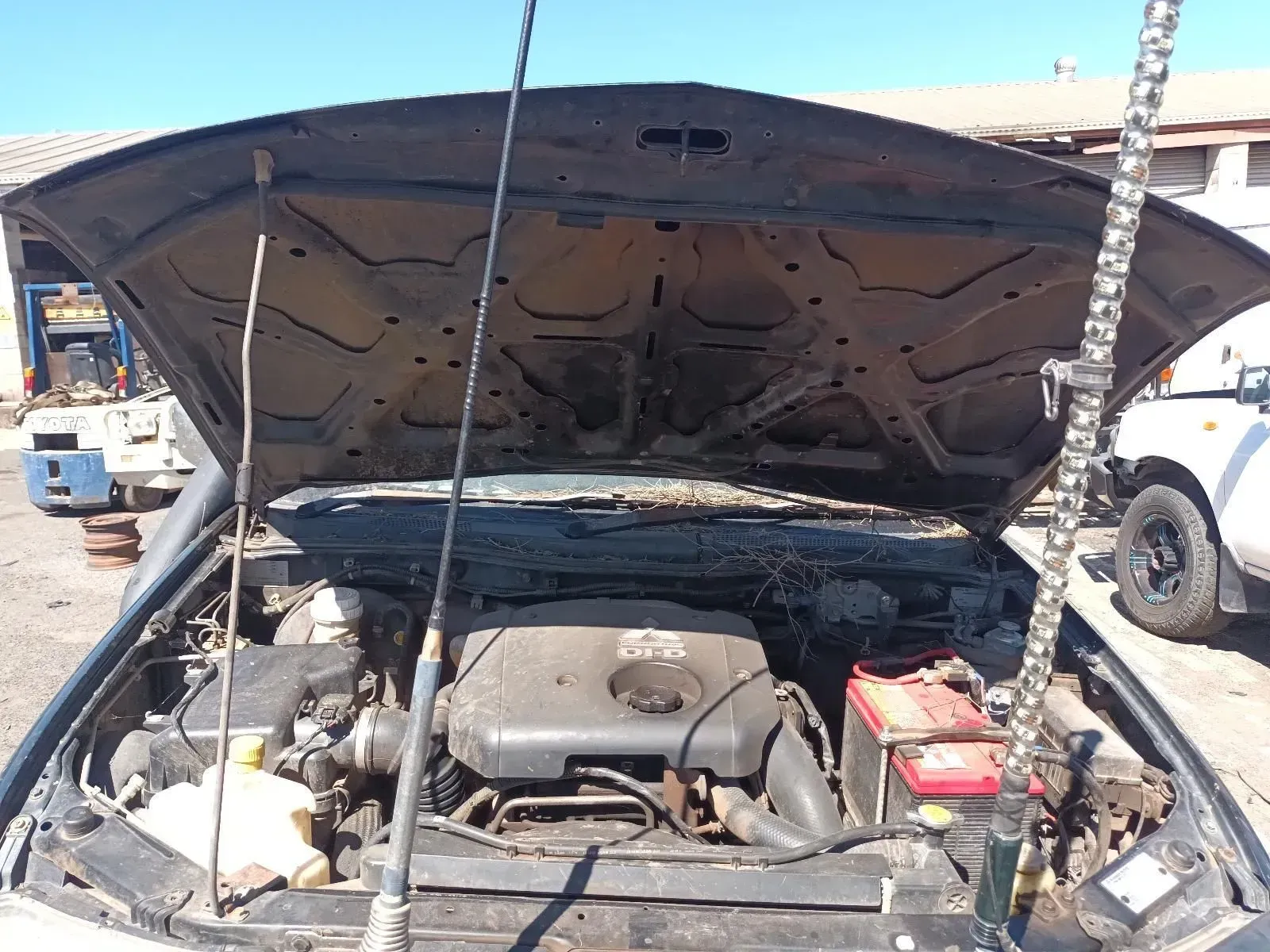 Car With Open Hood Showing Engine, Battery, and Various Components, Outdoors — South West 4WD Wreckers In Brisbane, QLD