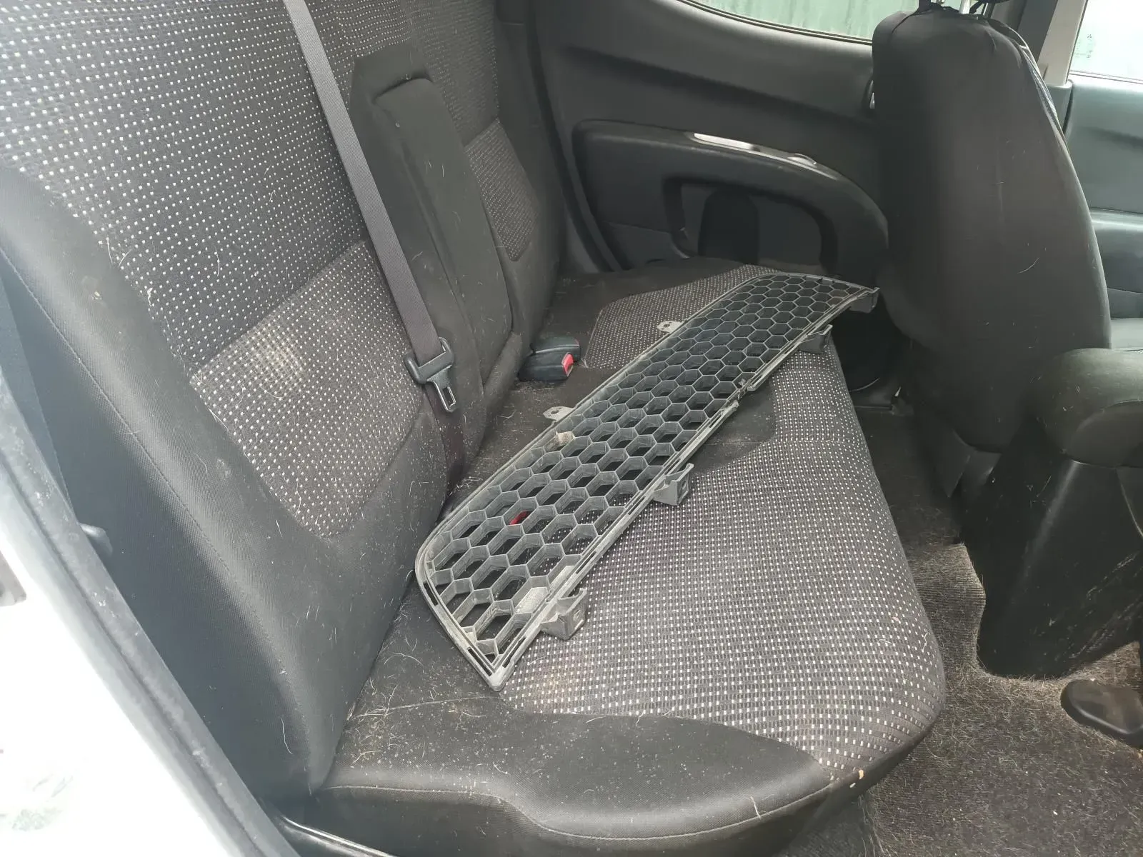 Black Car Back Seat With a Black Grill Resting on It, Covered in Dust — South West 4WD Wreckers In Brisbane, QLD