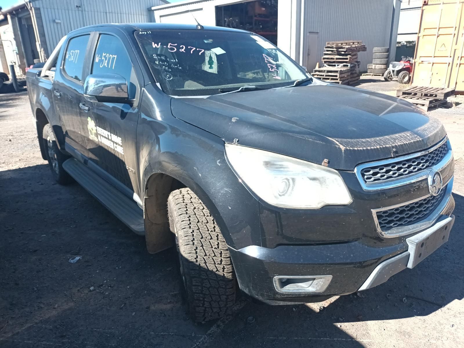 A Black Truck is Parked in a Parking Lot in Front of a Building — South West 4WD Wreckers In Harristown, QLD