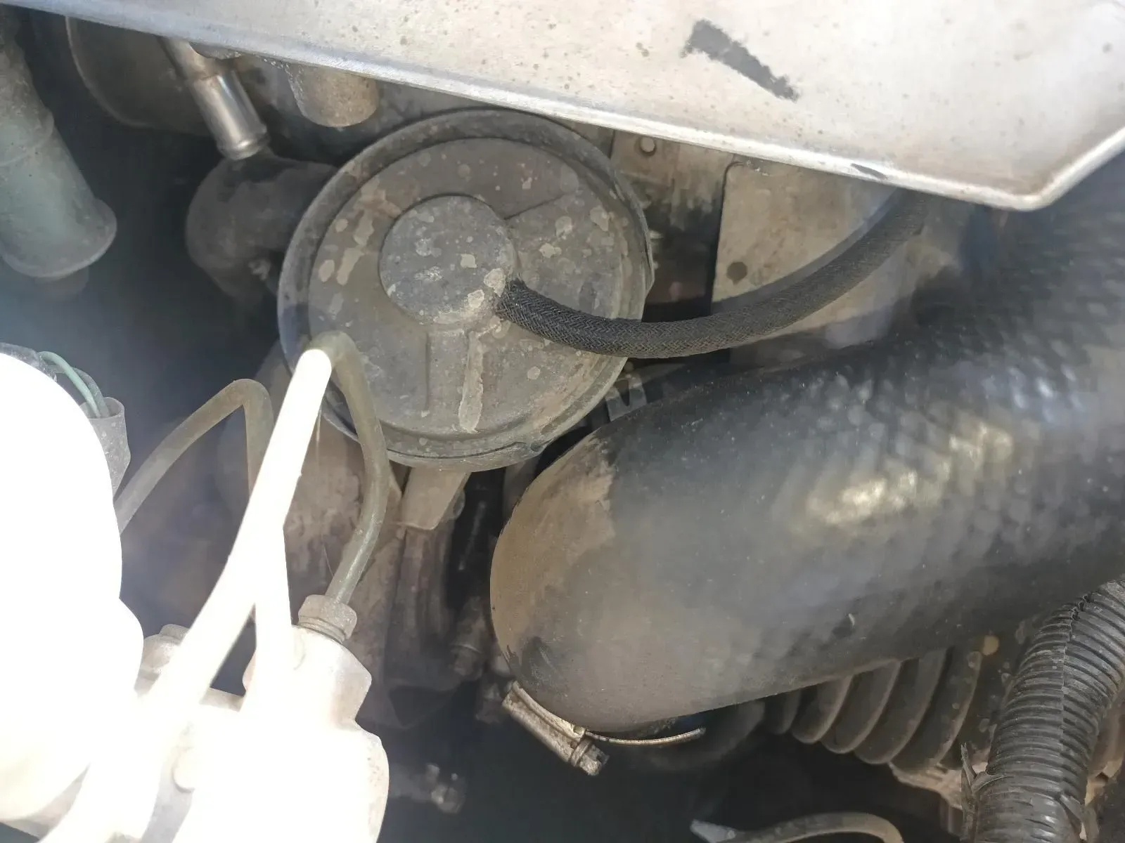 Engine Compartment With a Round, Black Component and Hoses — South West 4WD Wreckers In Brisbane, QLD