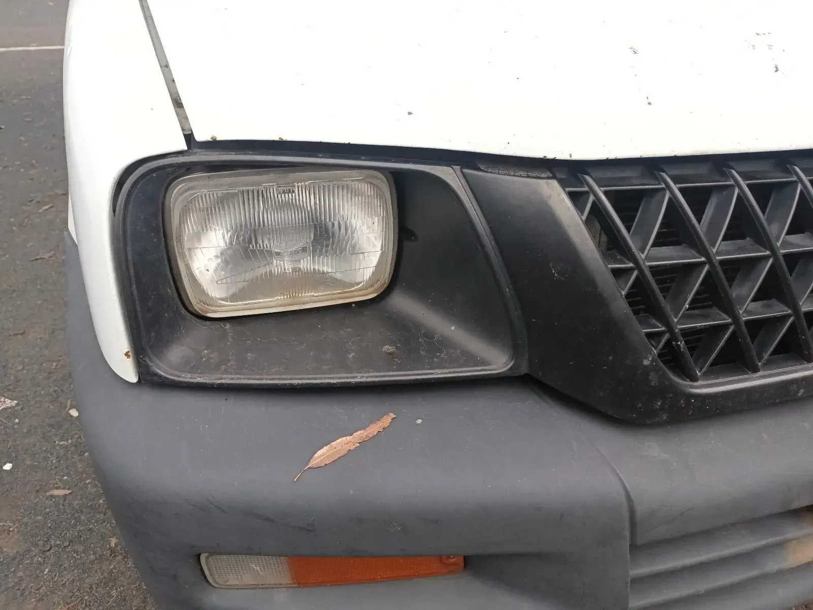 Close-up of a White Car's Front With a Square Headlight — South West 4WD Wreckers In Brisbane, QLD
