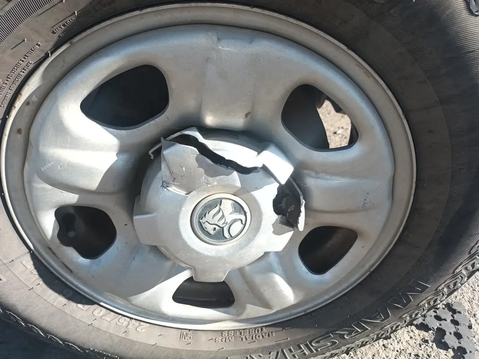 Damaged Hubcap on a Car Wheel With a Holden Logo, Showing Wear and Tears — South West 4WD Wreckers In Brisbane, QLD