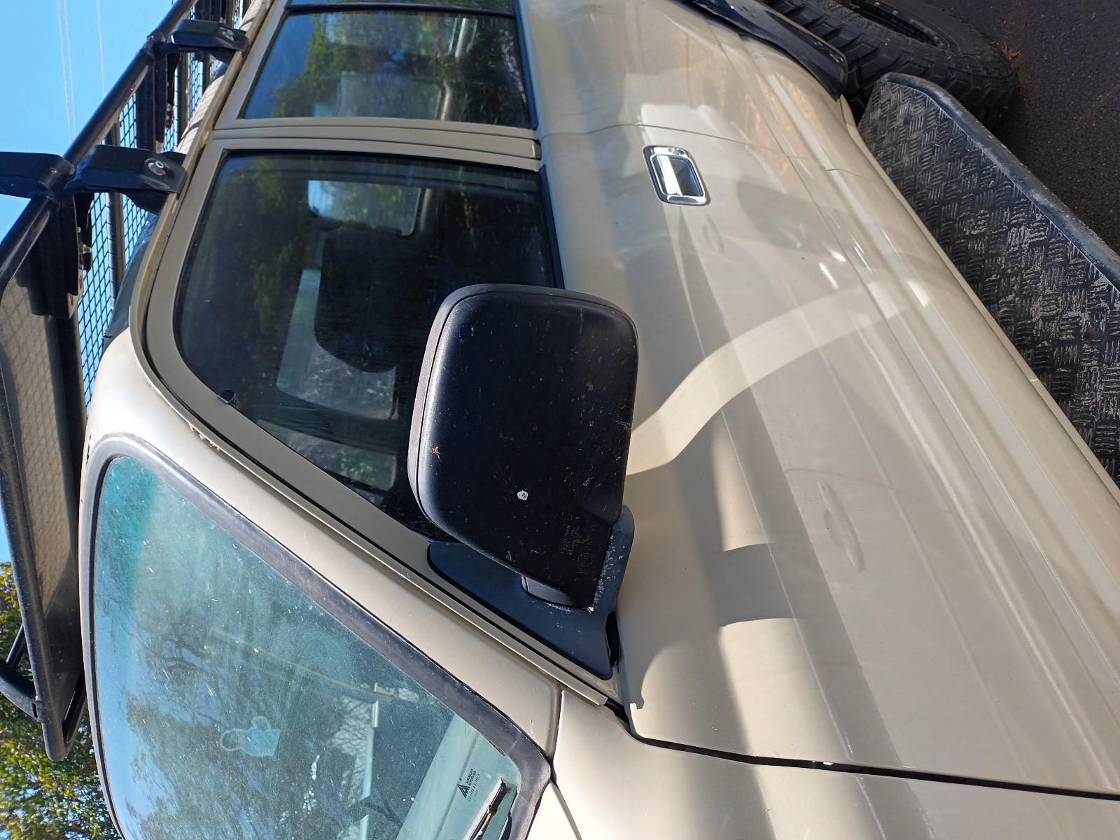 A White Truck with a Black Side Mirror is Parked on the Side of the Road — South West 4WD Wreckers in Harristown, QLD