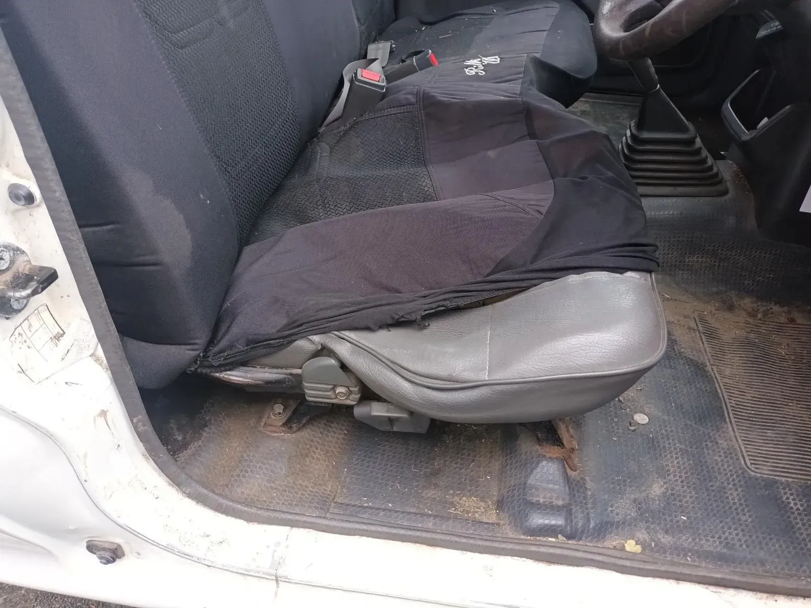 Black Seat Cover on a Gray Car Seat; Dirt on the Floor and Doorframe — South West 4WD Wreckers In Brisbane, QLD