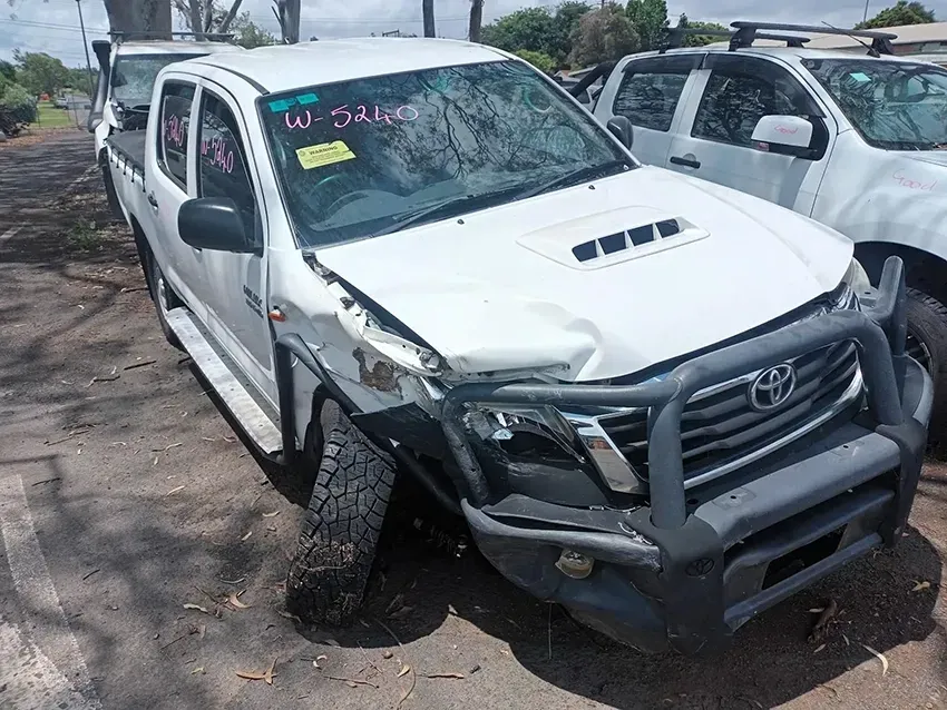 A White Truck With a Broken Bumper is Parked in a Lot — South West 4WD Wreckers In Brisbane, QLD