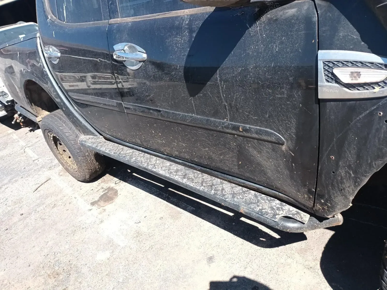 Black Pickup Truck With a Side Step, Parked on Concrete — South West 4WD Wreckers In Brisbane, QLD