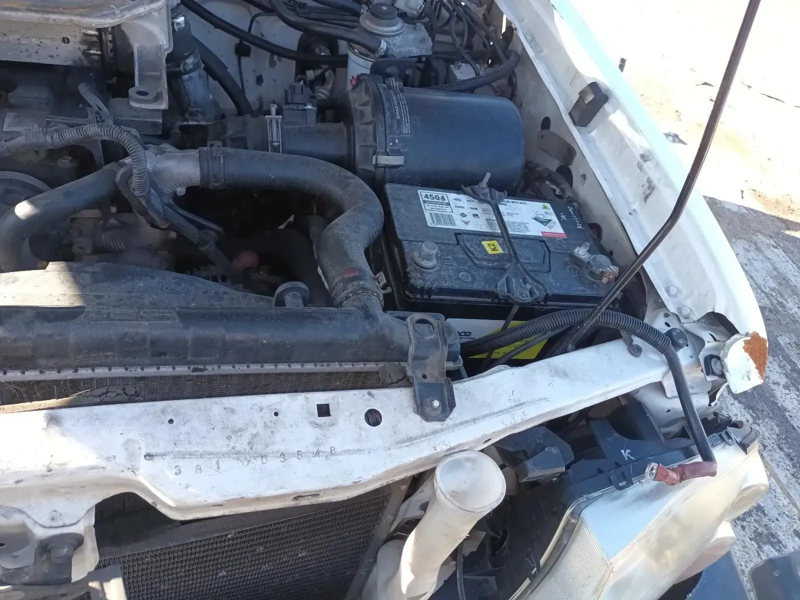 White Car Engine Bay With Battery and Hoses Visible — South West 4WD Wreckers In Brisbane, QLD