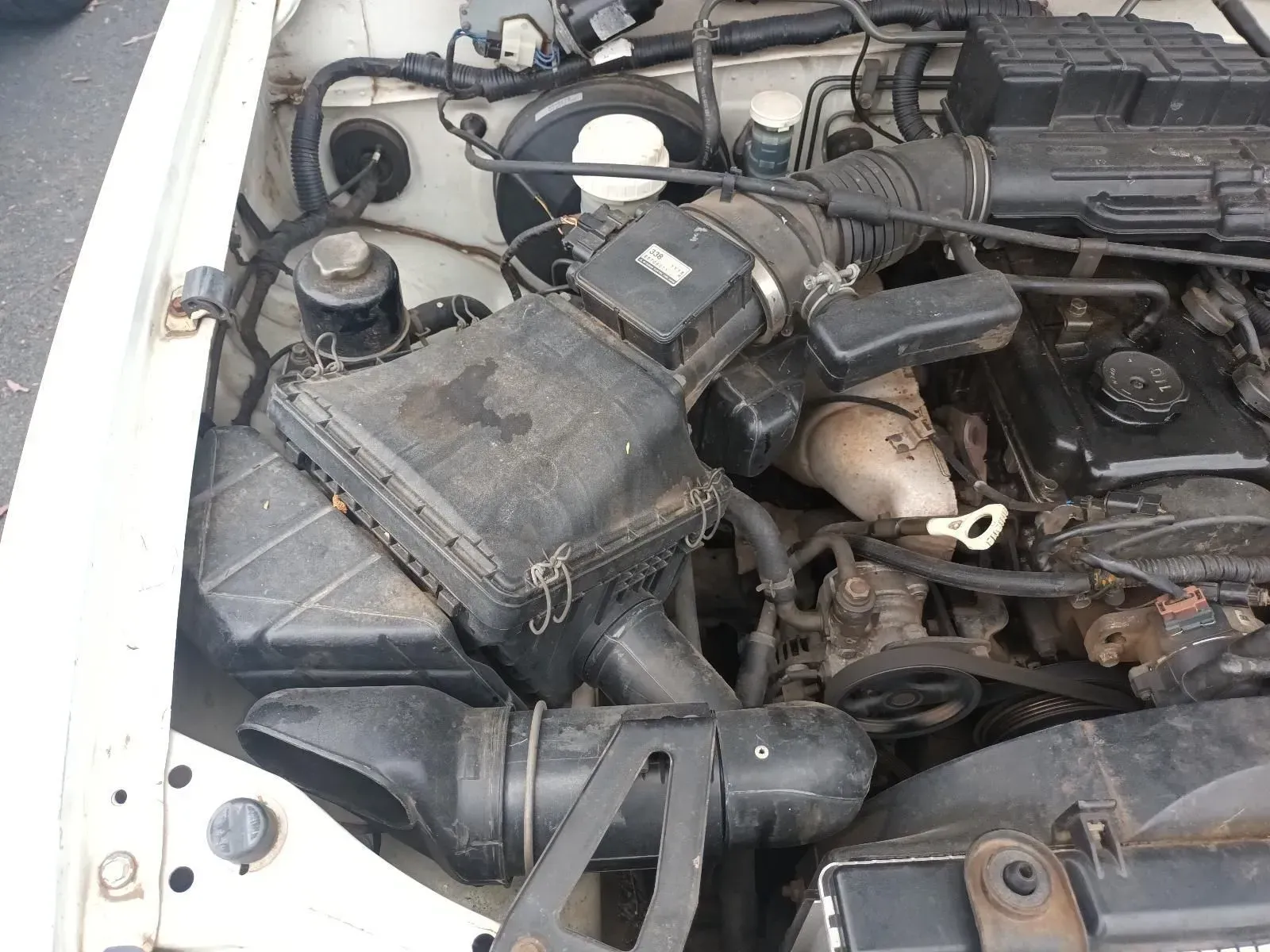 White Car Engine Bay, Various Black Parts, Air Intake, and Filters — South West 4WD Wreckers In Brisbane, QLD