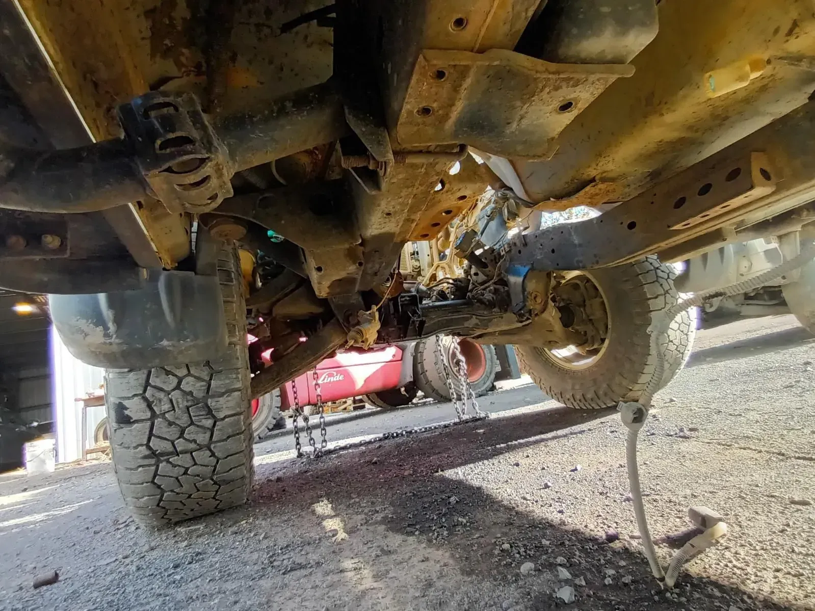 Underside of a Rusty Vehicle Chassis, Tyres Visible, Shot Taken Outdoors — South West 4WD Wreckers In Brisbane, QLD