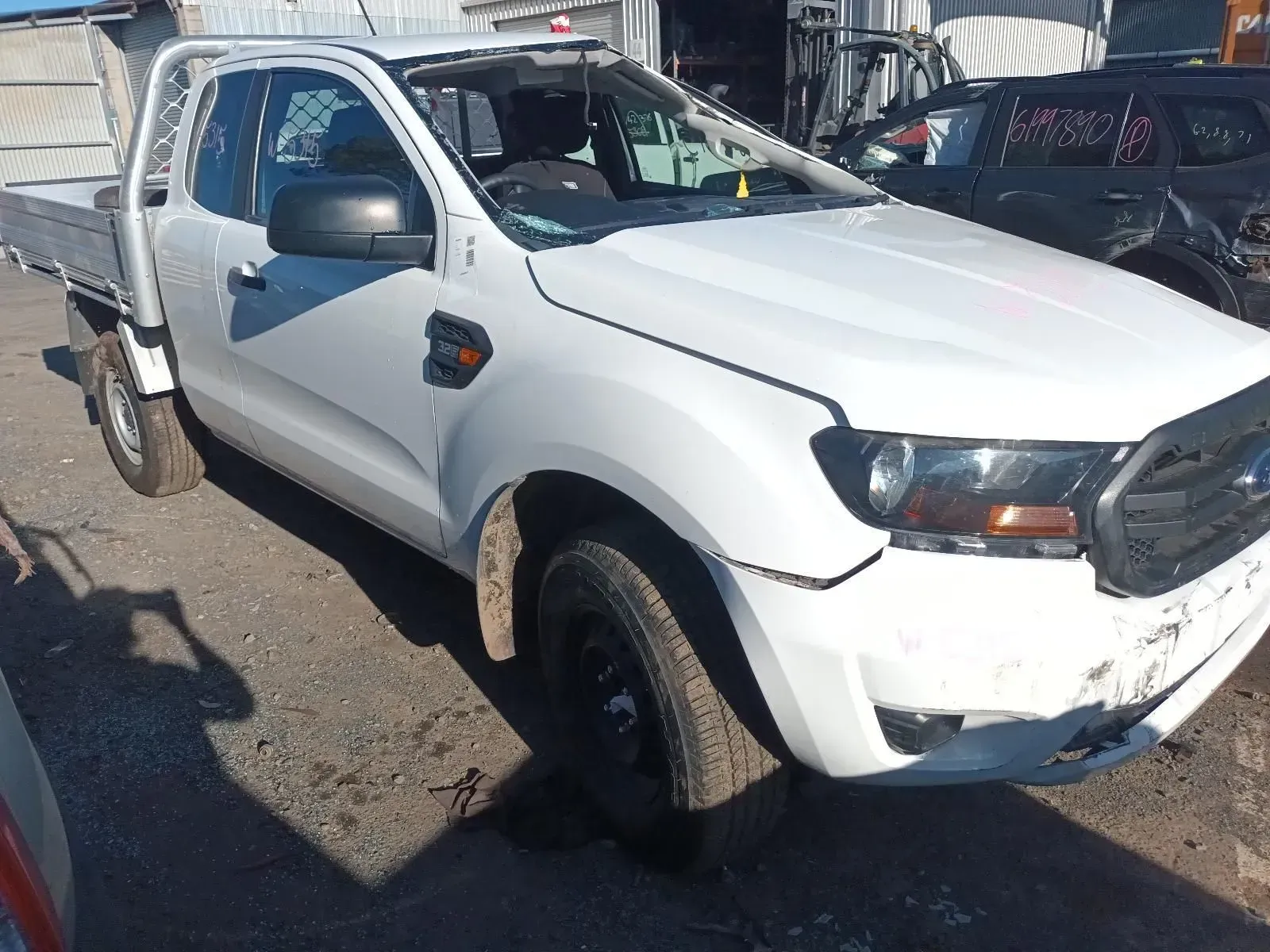 White Ford Ranger Pickup Truck, Damaged Front, Flatbed, Parked in a Salvage Yard — South West 4WD Wreckers In Brisbane, QLD