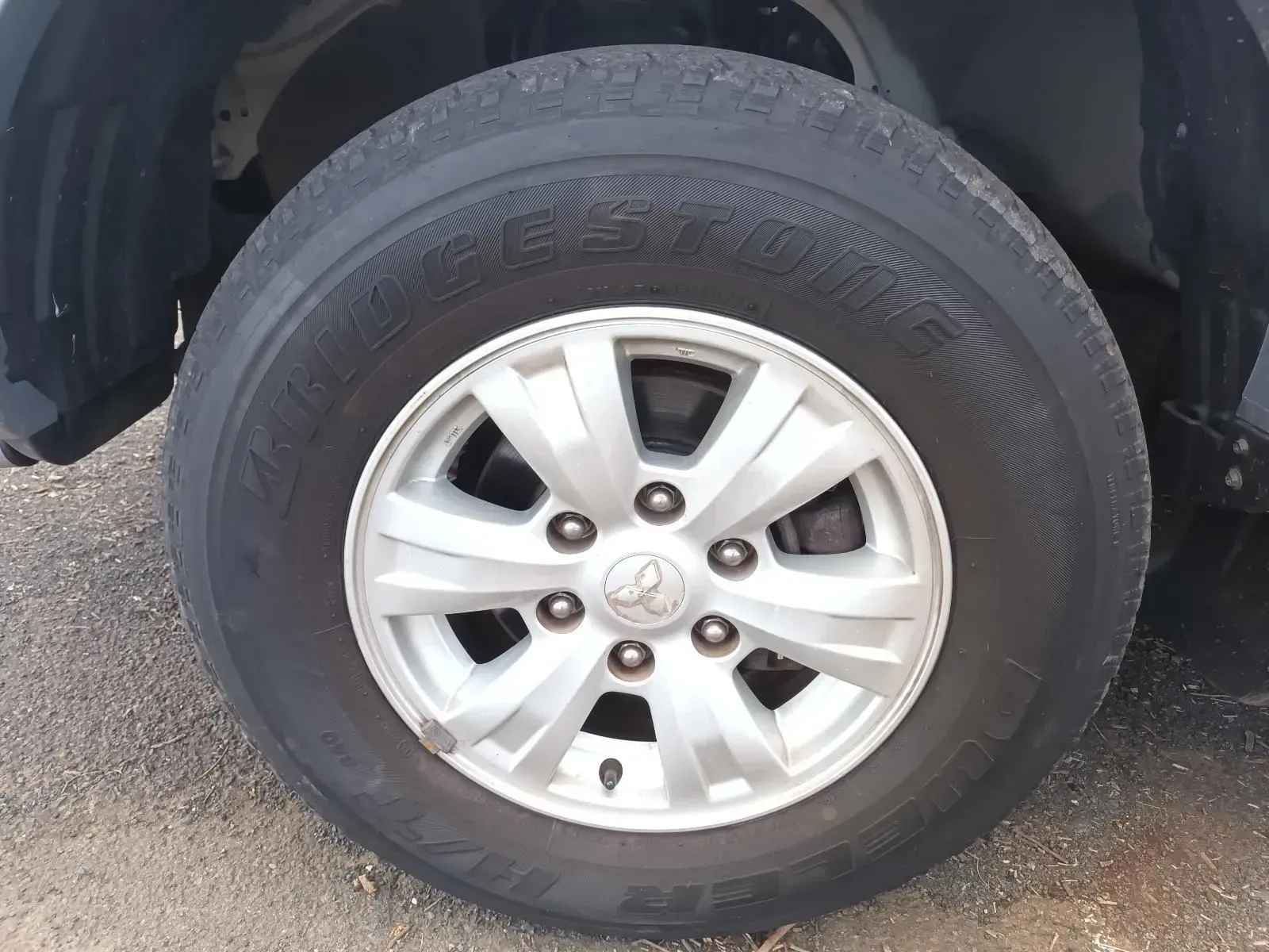 Car Tyre With a Silver Hubcap on Asphalt — South West 4WD Wreckers In Brisbane, QLD