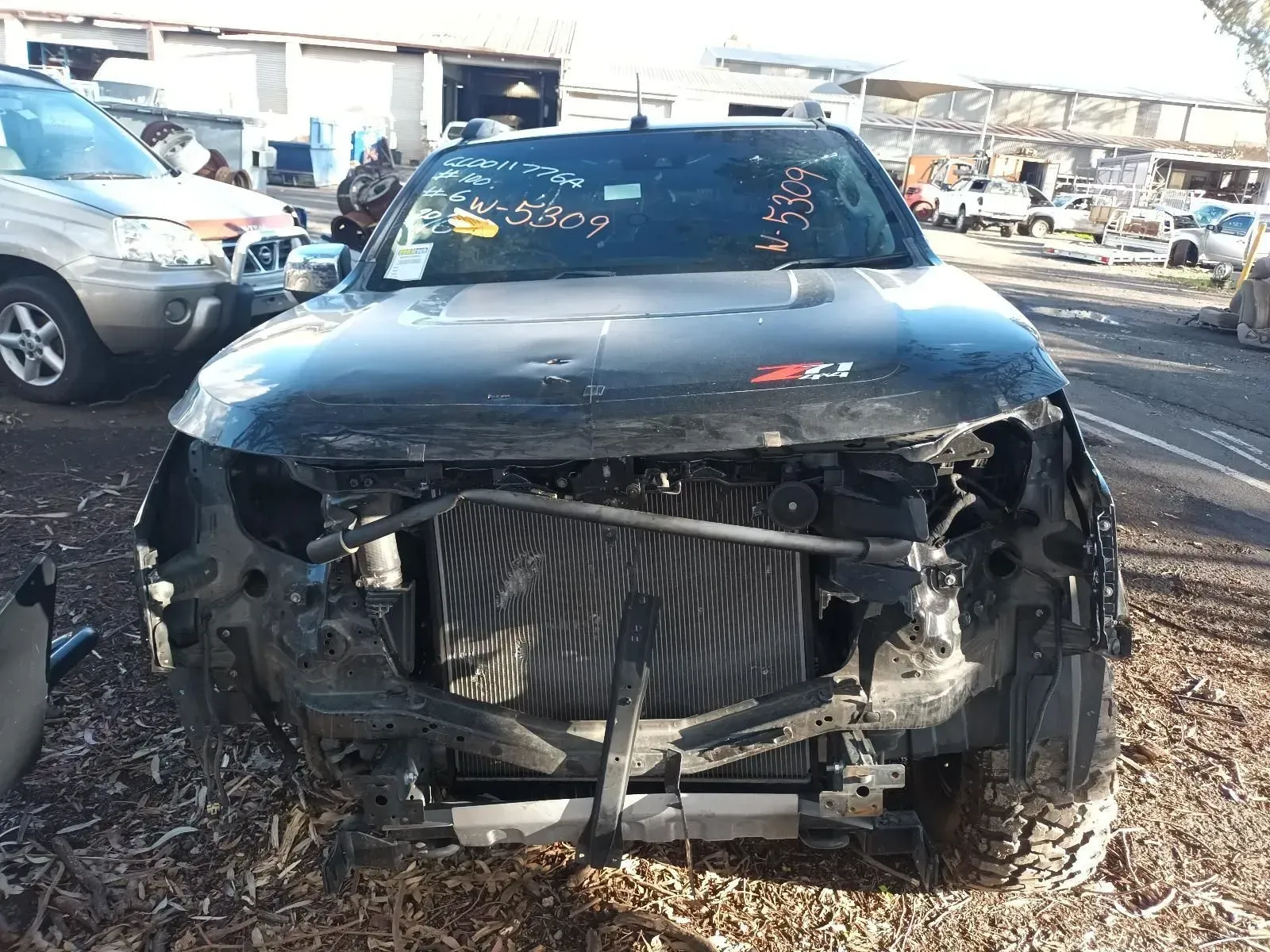 Black Car With Front End Damage in a Junkyard — South West 4WD Wreckers In Brisbane, QLD