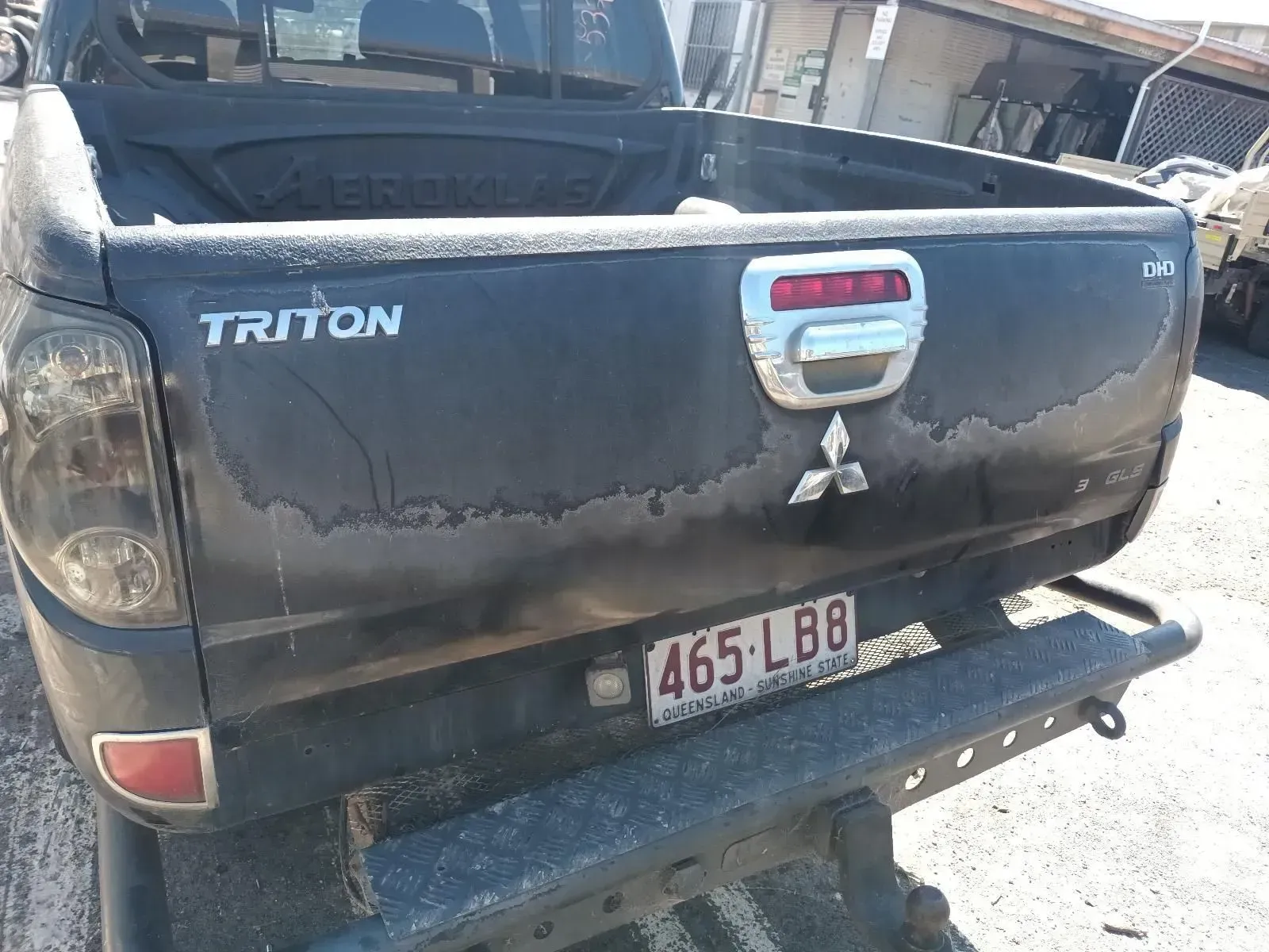Black Mitsubishi Triton Truck Tailgate With Peeling Paint and License Plate — South West 4WD Wreckers In Brisbane, QLD