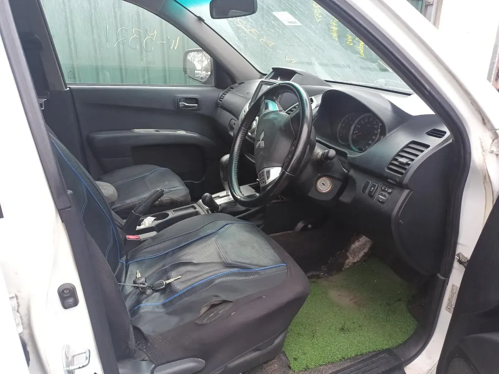 Interior of a White Car With Worn Blue Seat Upholstery and a Green Floor Mat — South West 4WD Wreckers In Brisbane, QLD
