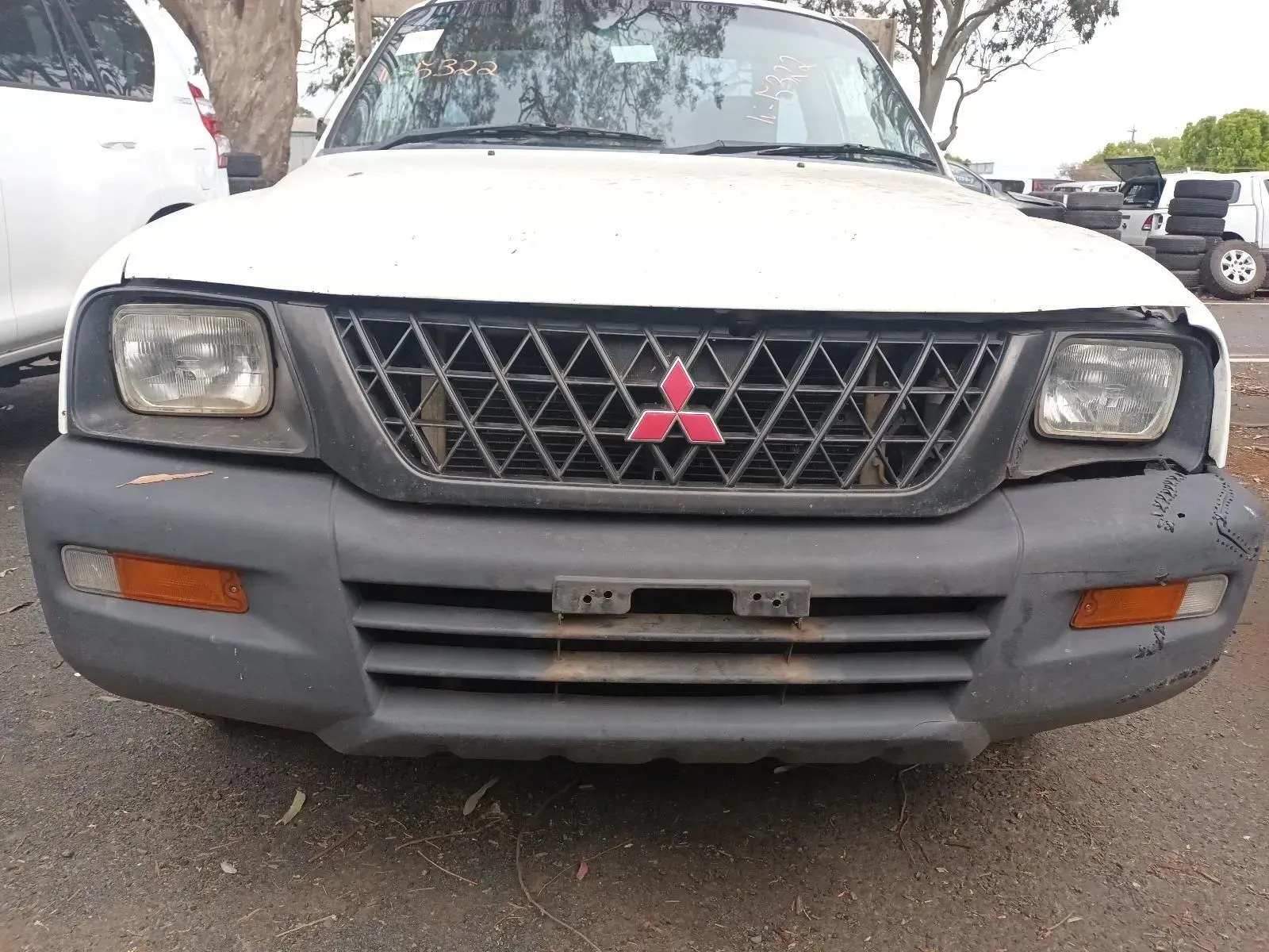 White Mitsubishi Triton Pickup Truck With Damaged Front Bumper and Red Logo — South West 4WD Wreckers In Brisbane, QLD