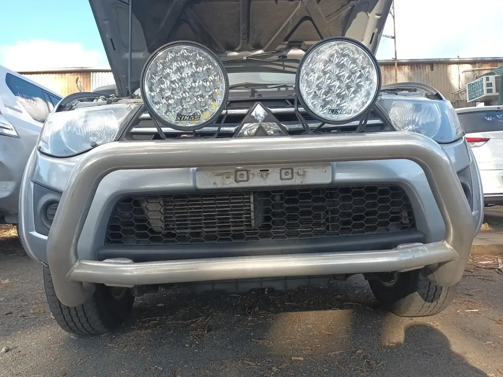 A Silver Mitsubishi Truck With the Hood Up, Spotlights, and a Bull Bar — South West 4WD Wreckers In Brisbane, QLD