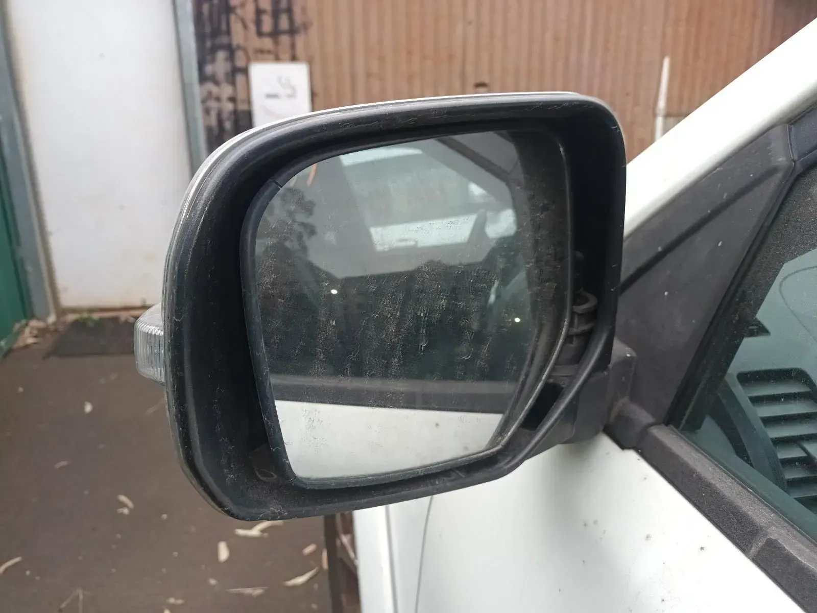 Dirty Side View Mirror on a White Vehicle, Reflecting a Blurred Outdoor Scene — South West 4WD Wreckers In Brisbane, QLD