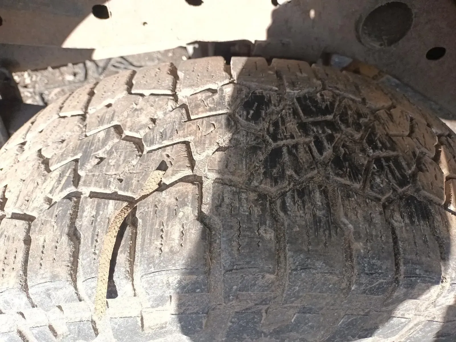 Spare Tyre, Weathered and Worn With Deep Treads, Mounted Under a Vehicle — South West 4WD Wreckers In Brisbane, QLD