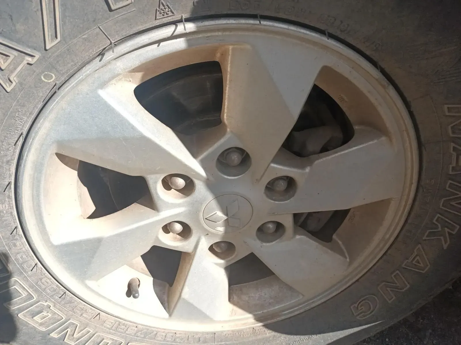 Close-up of a Dirty Silver Car Wheel With Six Lug Nuts and a Five-spoke Design — South West 4WD Wreckers In Brisbane, QLD
