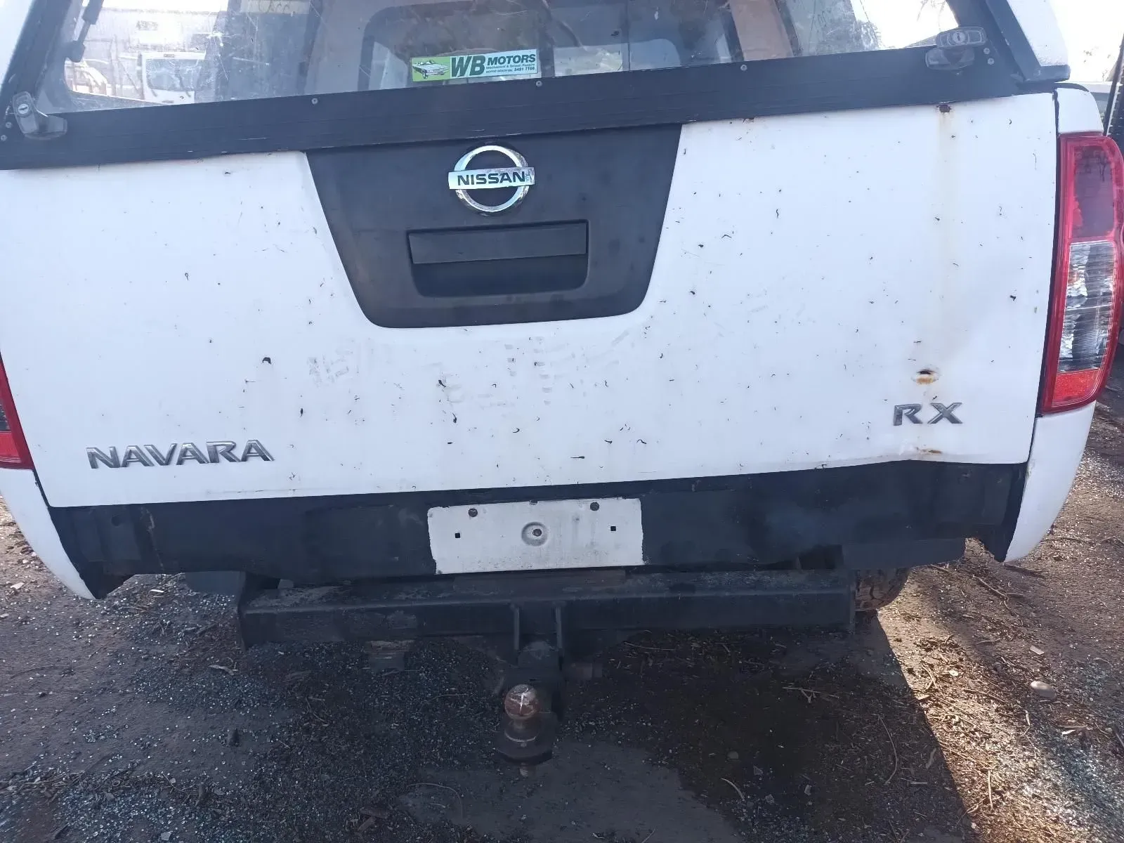 Rear of a White Nissan Navara Rx Pickup Truck With a Tow Hitch, Outdoors — South West 4WD Wreckers In Brisbane, QLD