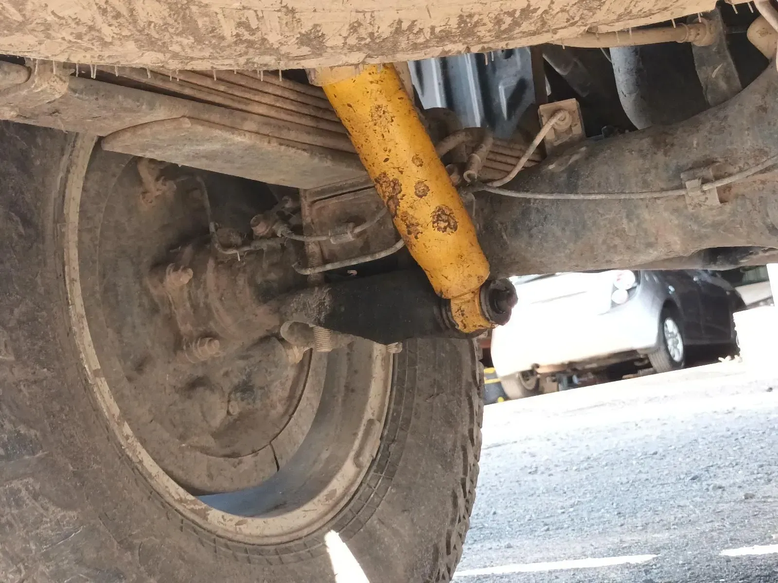Yellow Shock Absorber and Tyre on the Underside of a Vehicle, Likely Off-road — South West 4WD Wreckers In Brisbane, QLD