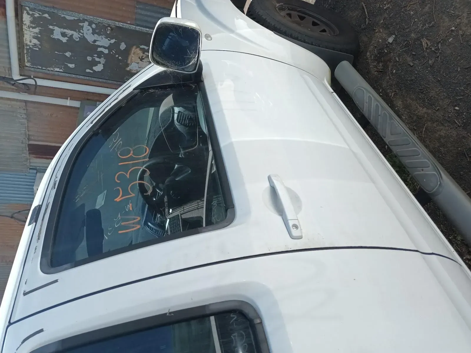 White Car Door With Side Mirror, Handle, and Window, at a Junkyard — South West 4WD Wreckers In Brisbane, QLD