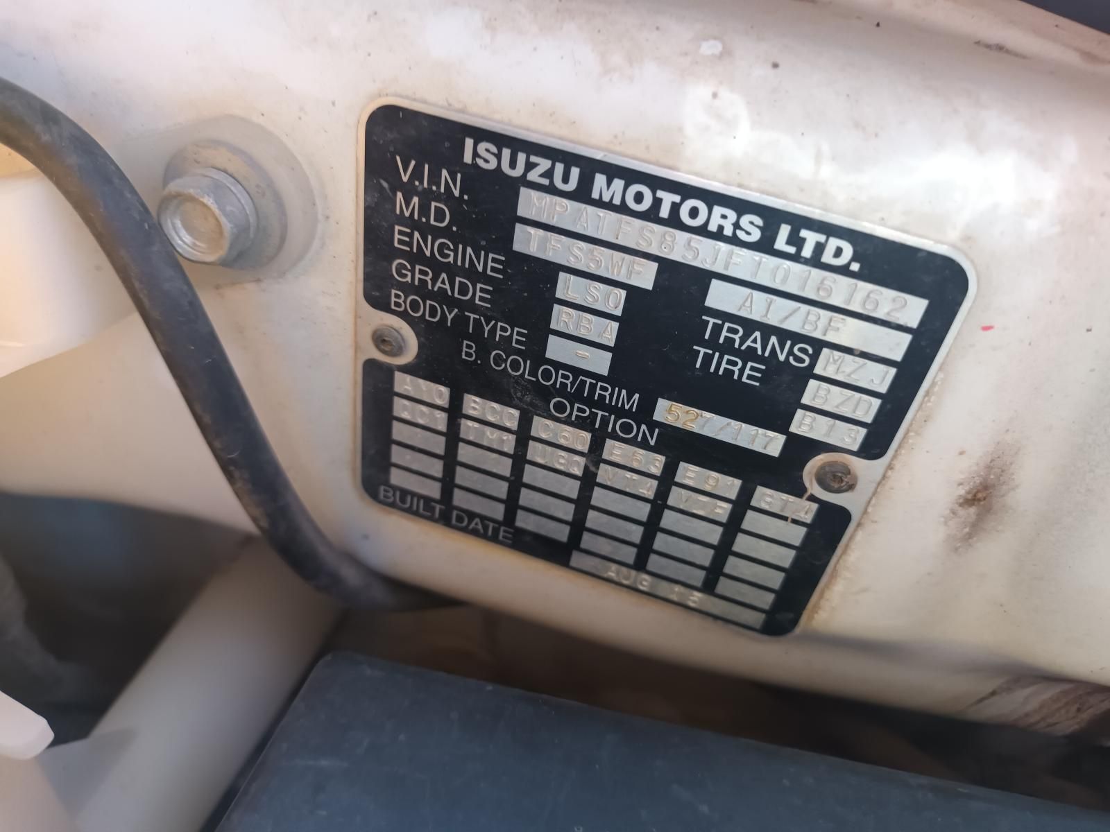 A Close Up of a Isuzu Motors Ltd. License Plate on a White Car — South West 4WD Wreckers In Brisbane, QLD