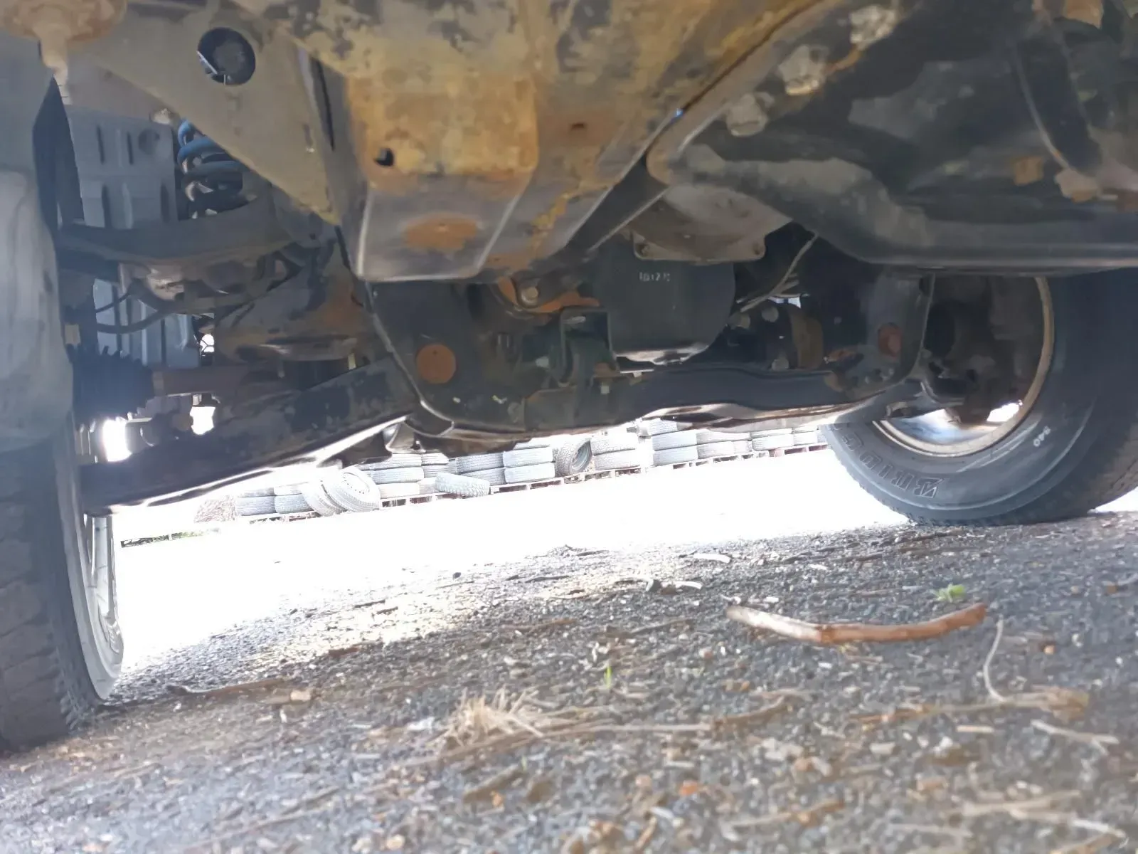 Undercarriage of a Rusty Vehicle, Showing Suspension and Tyres on Pavement — South West 4WD Wreckers In Brisbane, QLD