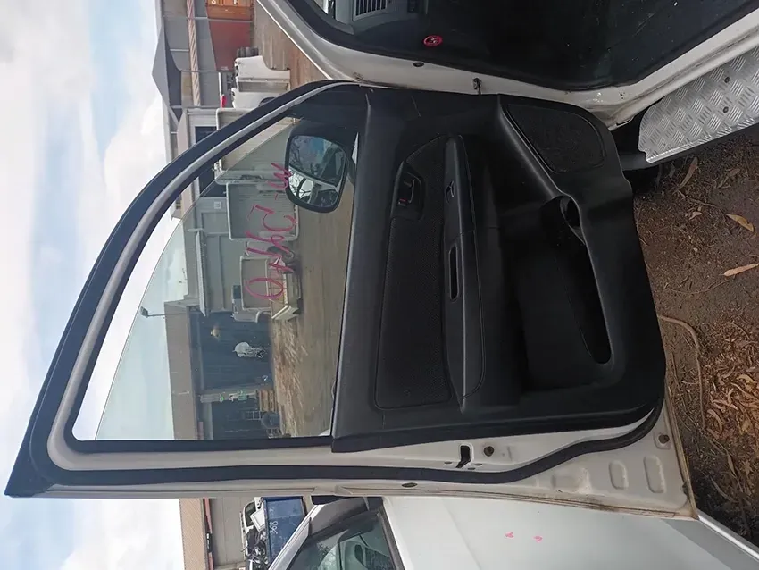 A White Car with the Door Open is Parked on the Side of the Road — South West 4WD Wreckers In Brisbane, QLD