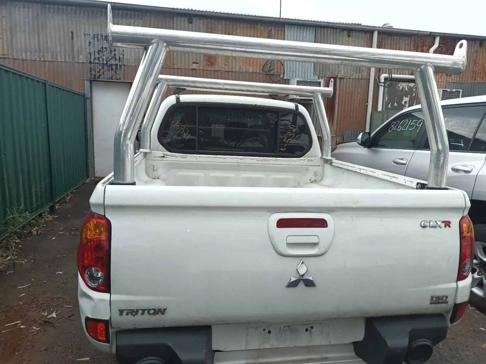 White Mitsubishi Triton Pickup Truck With a Silver Rack in an Outdoor Setting — South West 4WD Wreckers In Brisbane, QLD