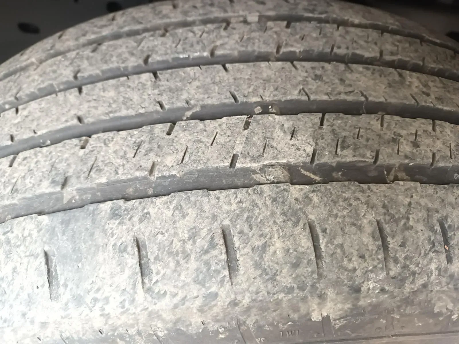 Close-up of a Dirty, Worn Tyre Showing Visible Tread Wear and Small Cracks — South West 4WD Wreckers In Brisbane, QLD