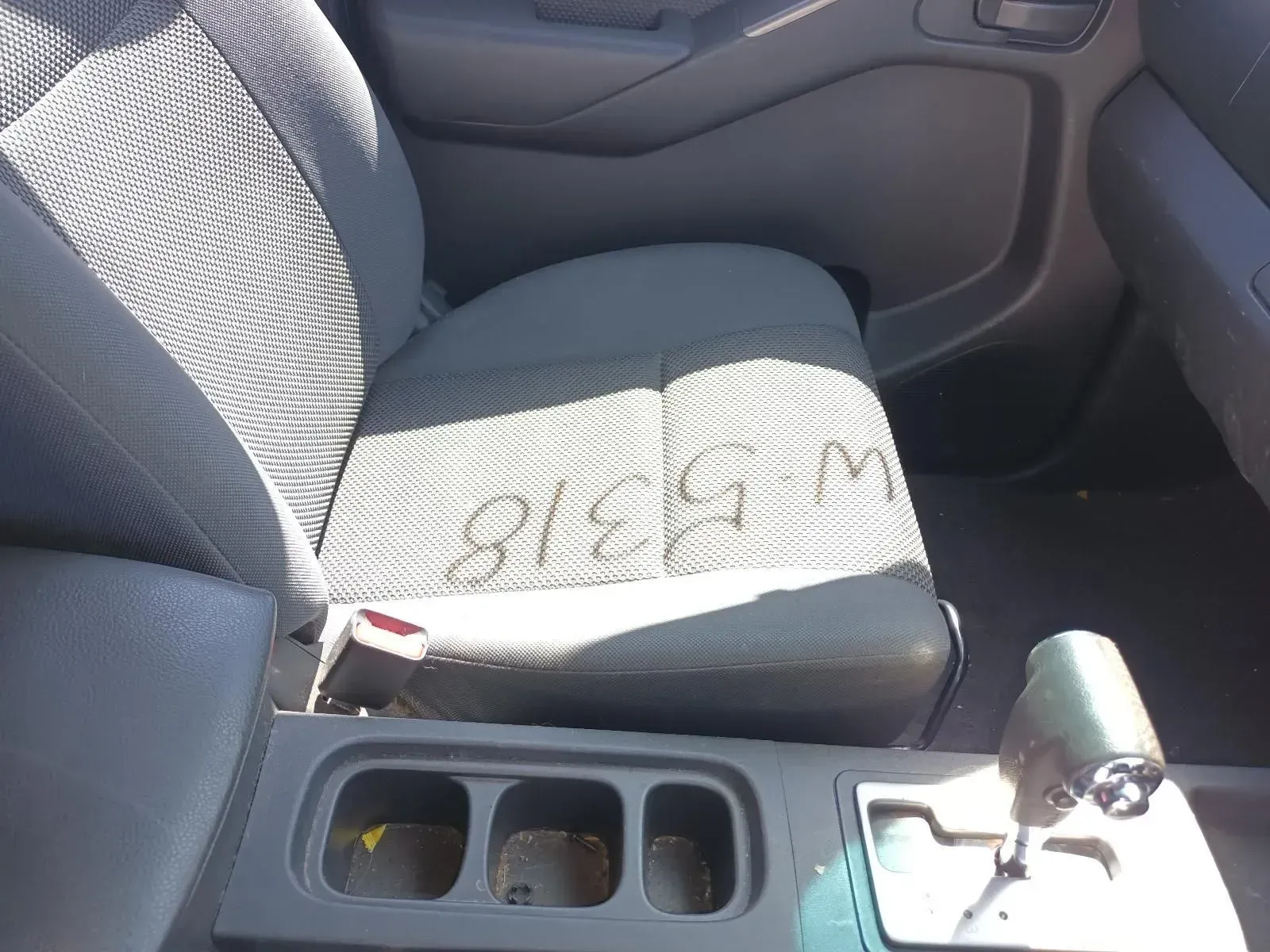 Gray Car Seat With Stains, Part of the Center Console, and a Gearshift Visible — South West 4WD Wreckers In Brisbane, QLD