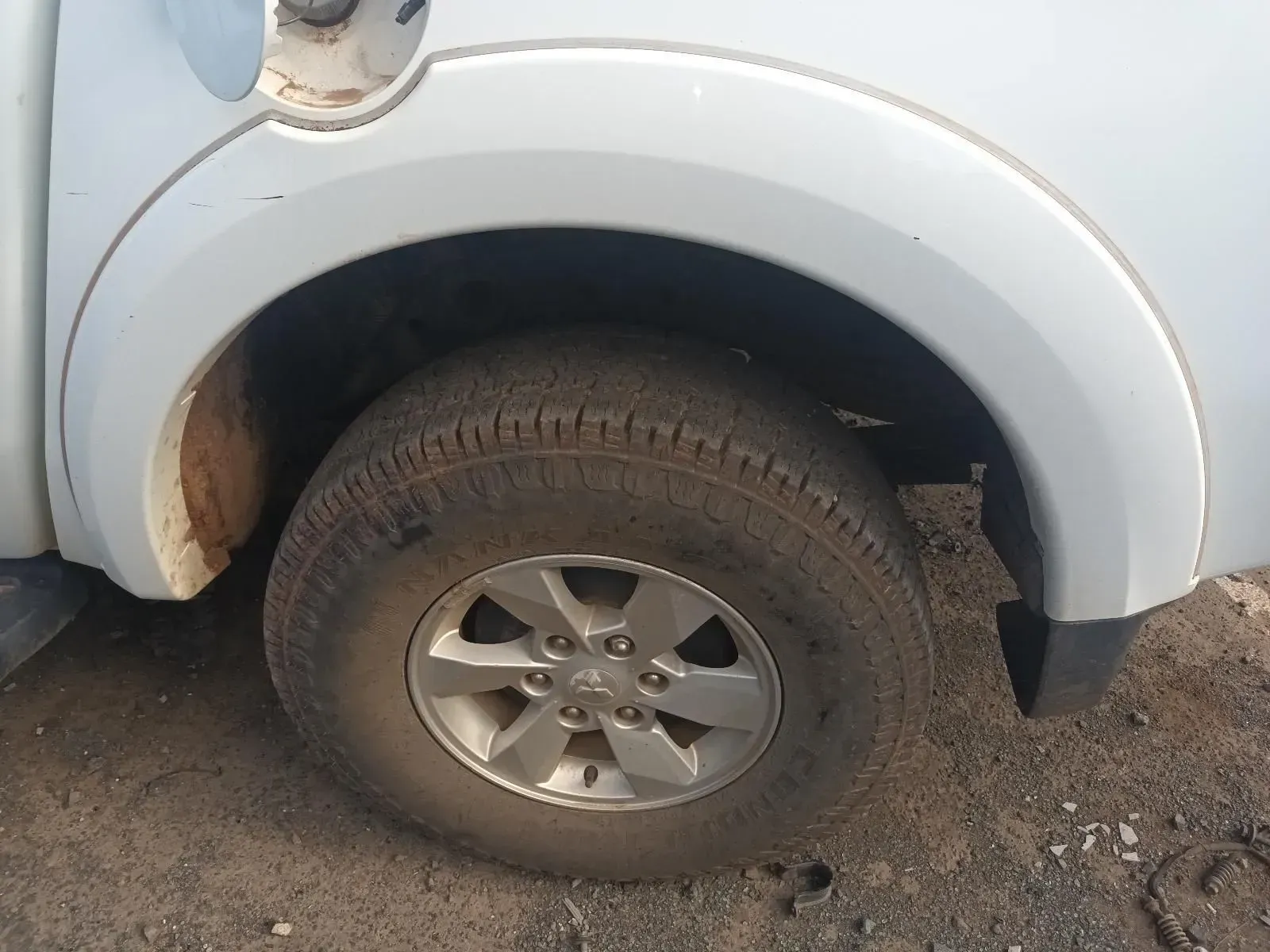 Close-up of a Dirty Tyre and Wheel on a White Truck With a Curved Fender — South West 4WD Wreckers In Brisbane, QLD