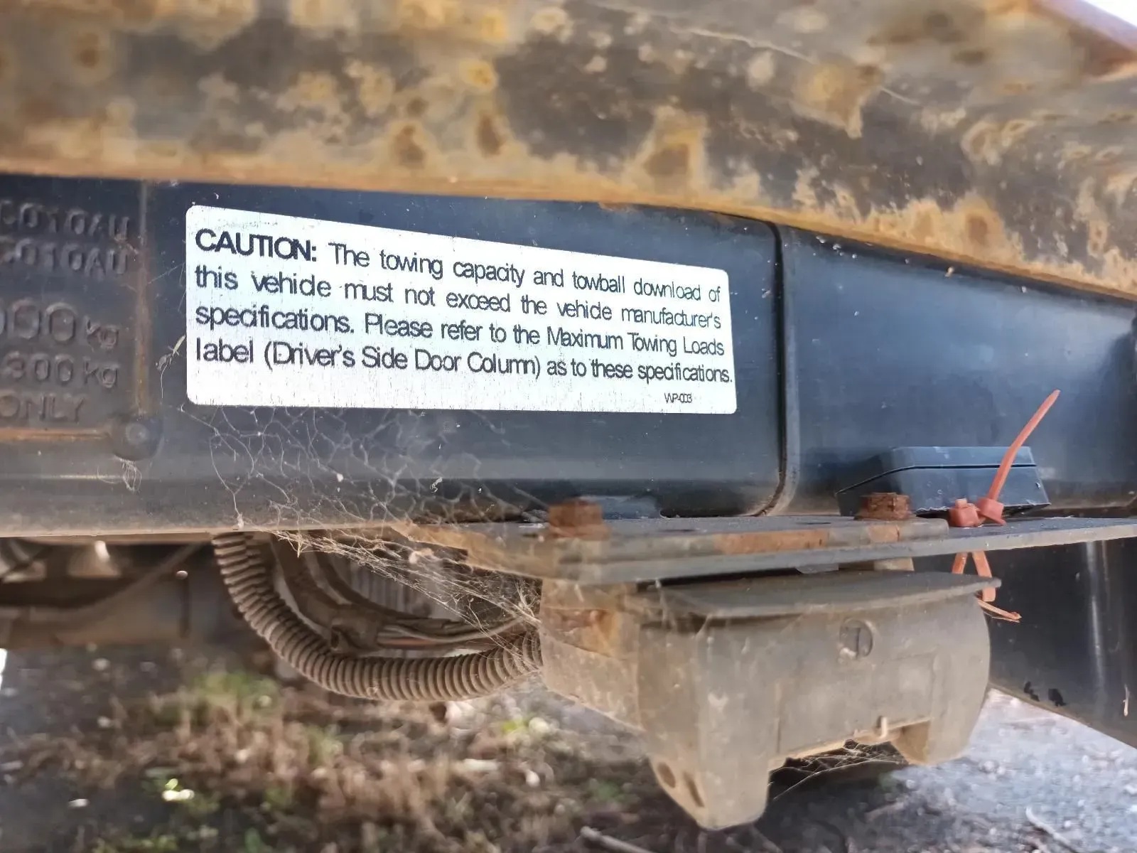 Close-up of a Corroded Vehicle Frame With a Warning Label About Towing Capacity — South West 4WD Wreckers In Brisbane, QLD