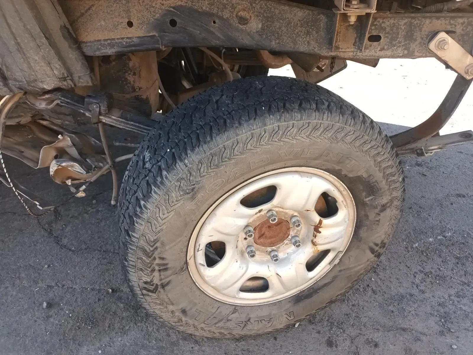 Flat Tyre on an Old, Damaged Vehicle. the Tyre is Deflated, and the Rim is Rusty — South West 4WD Wreckers In Brisbane, QLD