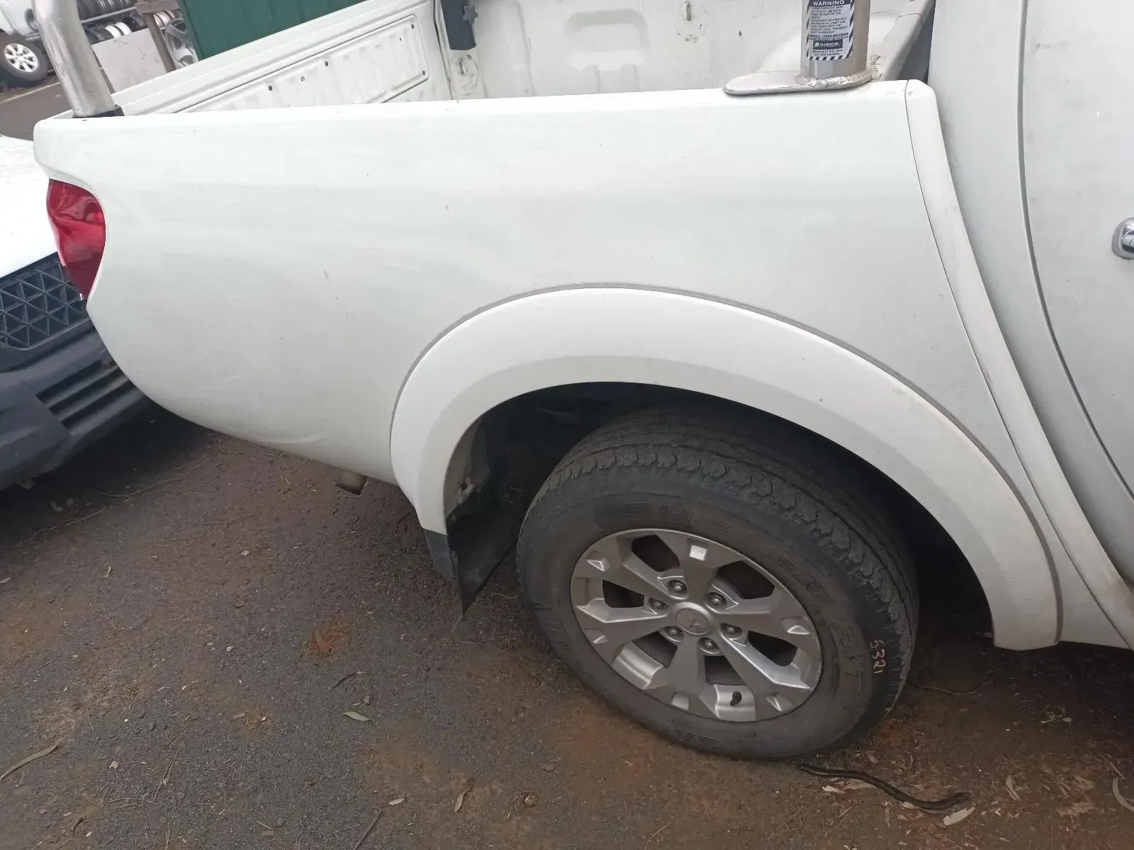 White Pickup Truck Rear Fender With Tyre, Parked Outdoors — South West 4WD Wreckers In Brisbane, QLD