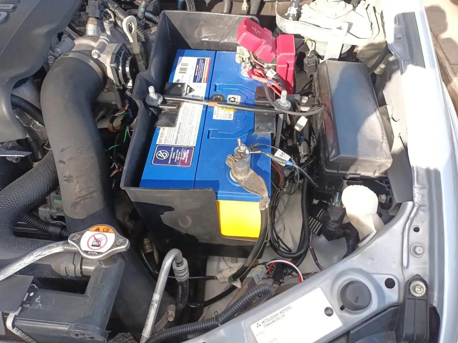 Blue Car Battery in an Engine Bay With Wiring and Accessories — South West 4WD Wreckers In Brisbane, QLD
