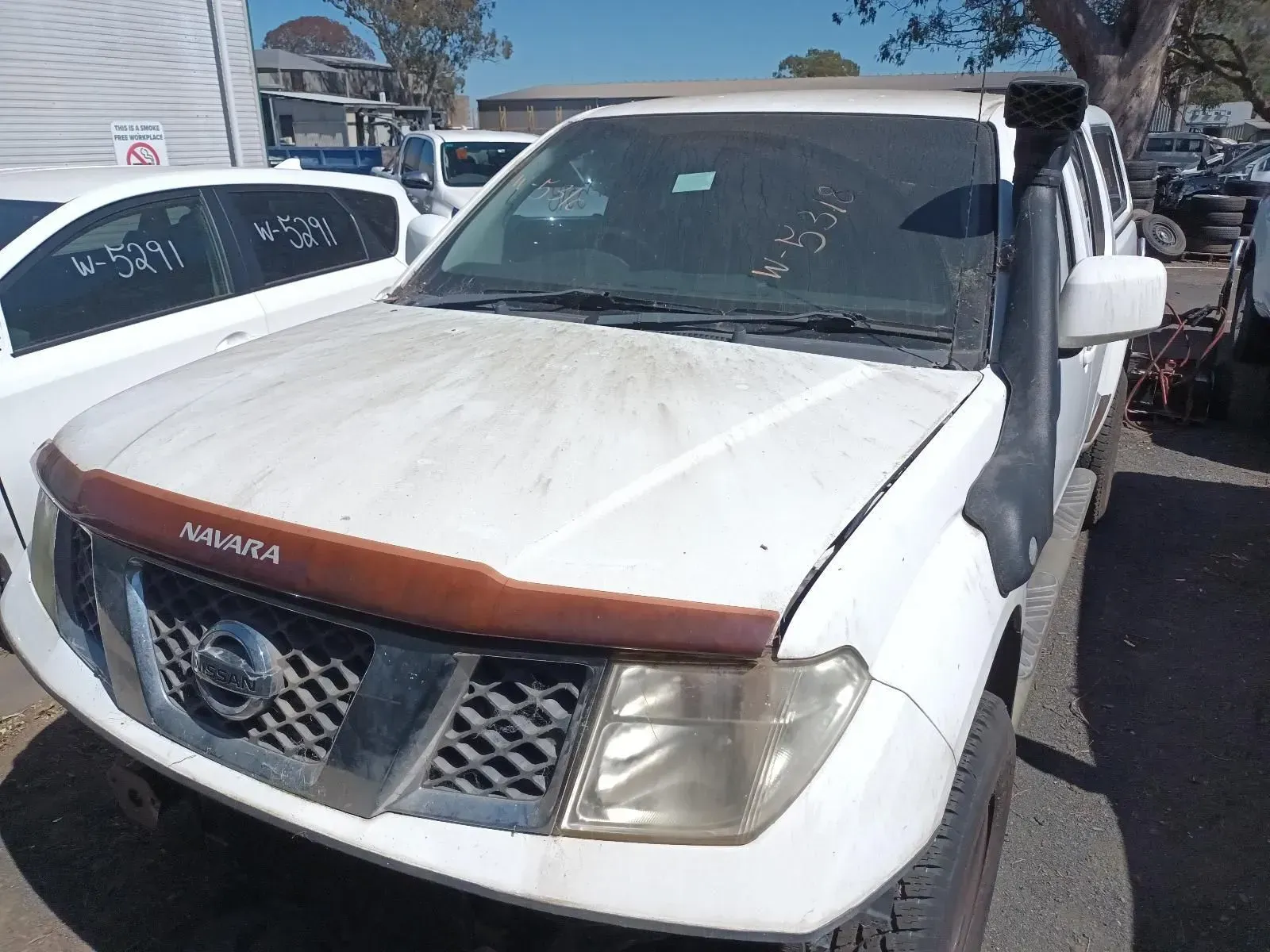 White Nissan Navara Pickup Truck at a Junkyard— South West 4WD Wreckers In Brisbane, QLD