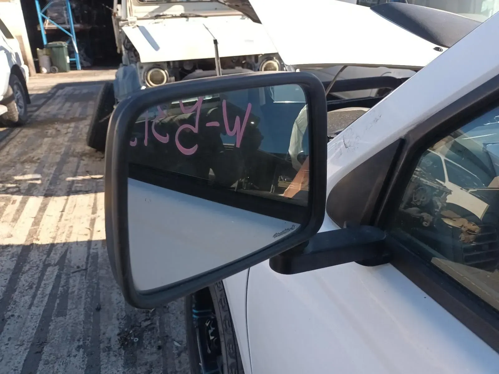Side Mirror on a White Car, in a Junkyard Setting — South West 4WD Wreckers In Brisbane, QLD